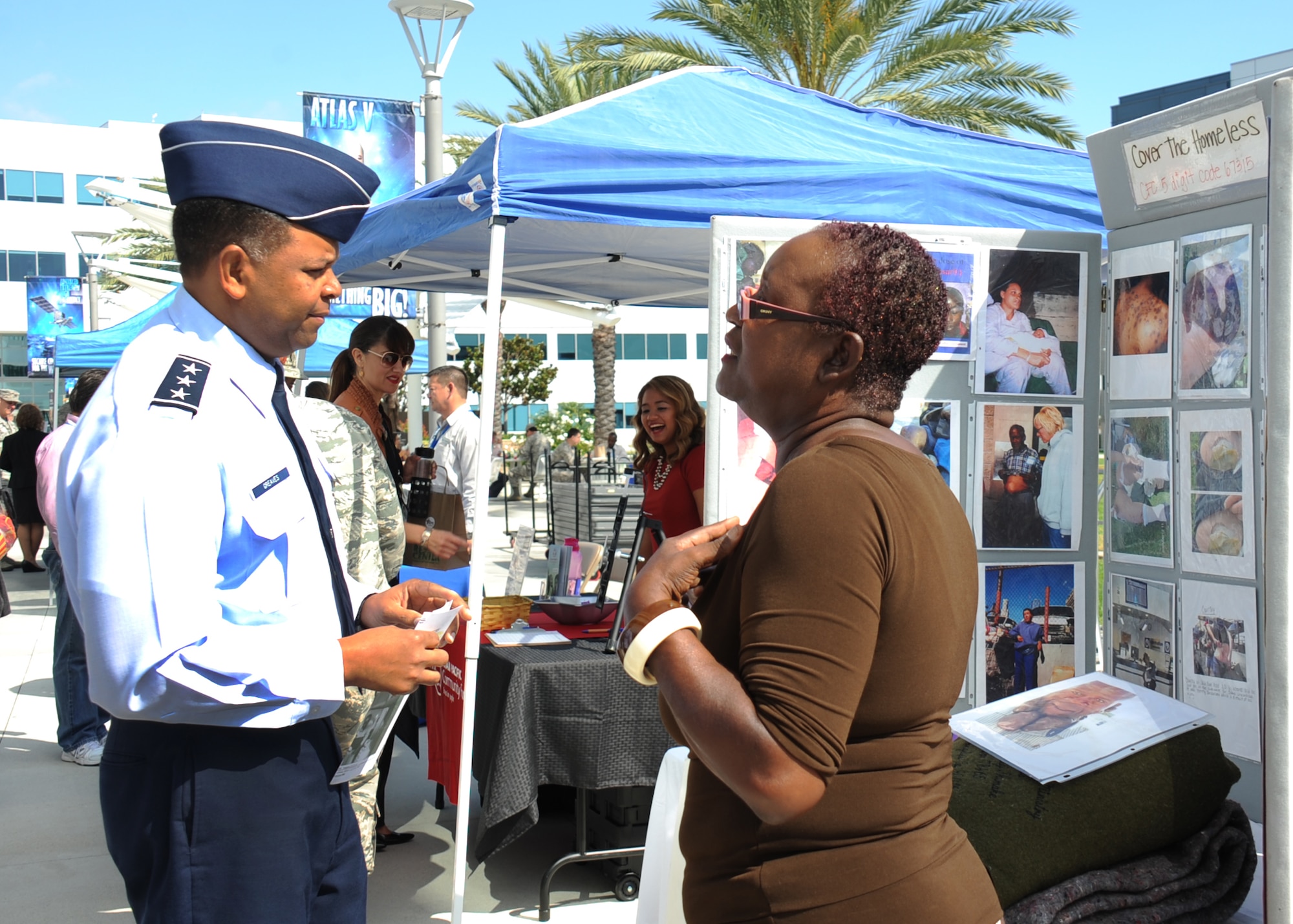 Lt. Gen. Samuel Greaves, SMC commander, talks with a representative from Cover the Homeless about her charity. The organization provides blankets, food clothing and transportation to homeless people in the Los Angeles area. (U.S Air Force photo by Van Ha)