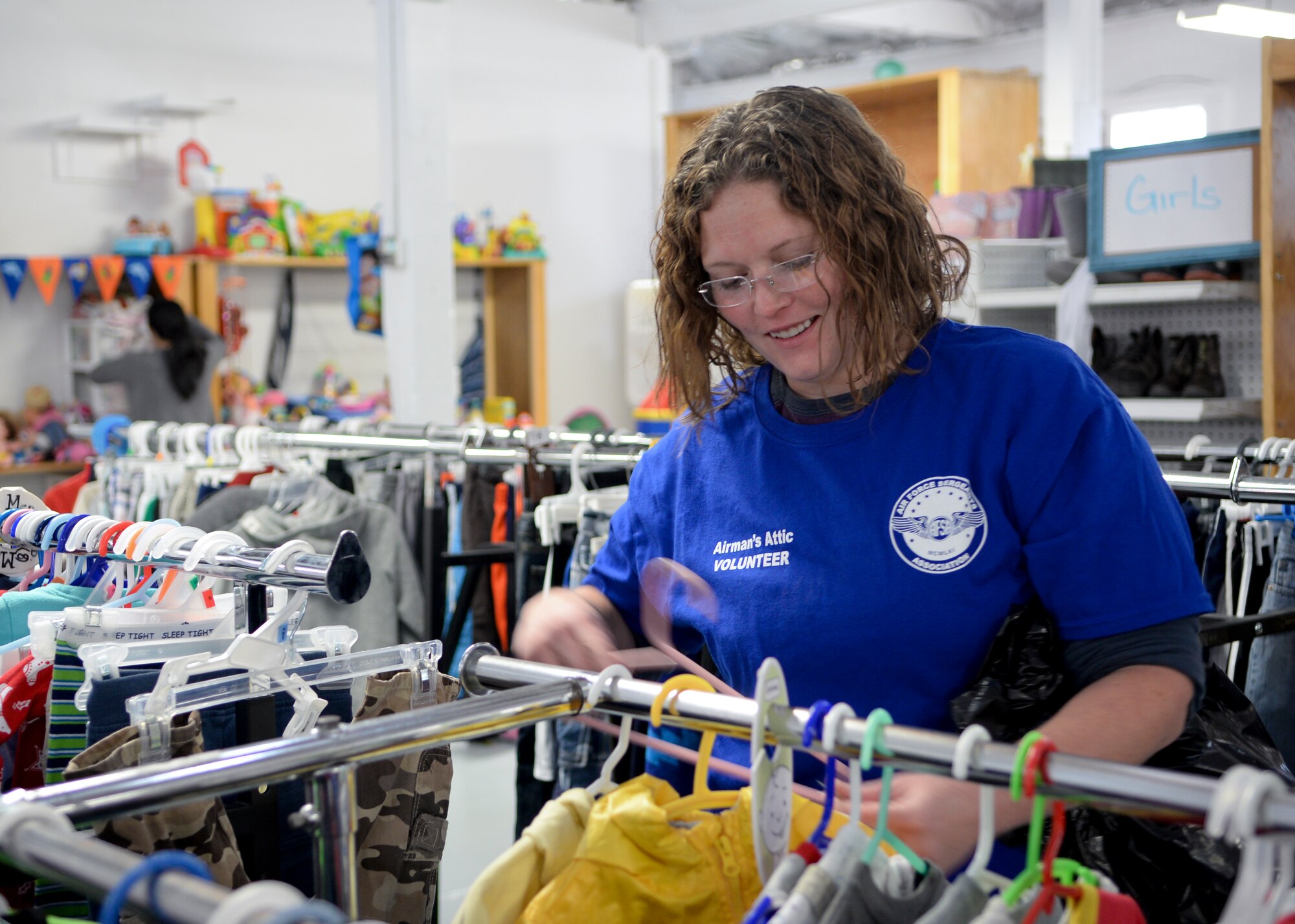 Kari Woods, an Airmen’s Attic volunteer, stocks the children’s clothing section during the facility’s grand re-opening on F.E. Warren Air Force Base, Wyo., Oct. 3, 2015. The Airmen’s Attic is stocked by donated items from the community, and all items are free. (U.S. Air Force photo by Airman 1st Class Malcolm Mayfield)