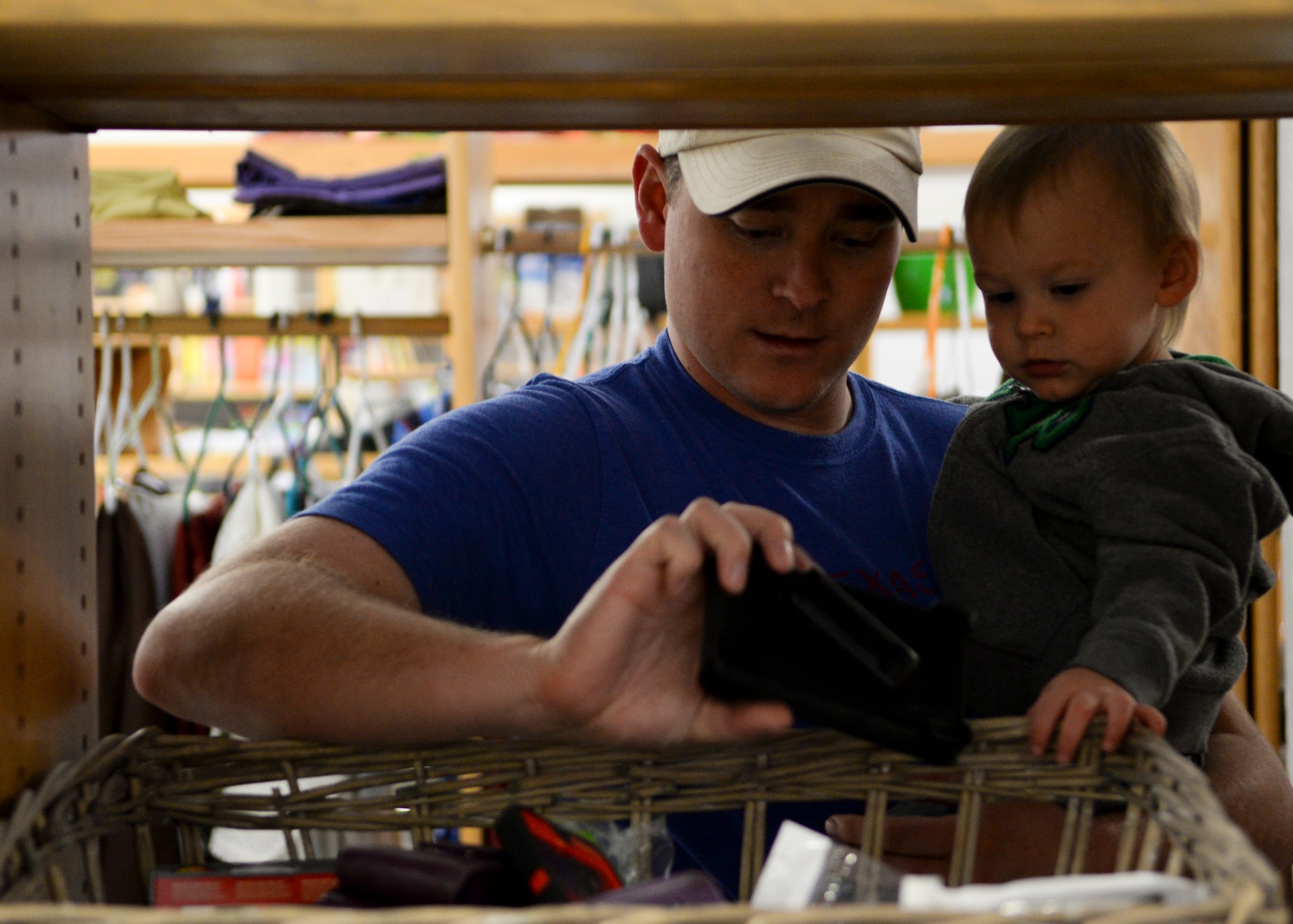 Bryce Stringer and his son Calum, 1, look through shelves in the Airmen’s Attic during the facilities grand re-opening on F.E. Warren Air Force Base, Wyo., Oct. 3, 2015. Many old items were removed from the attic before the re-opening, giving visitors plenty of fresh items to look through. (U.S. Air Force photo by Airman 1st Class Malcolm Mayfield)