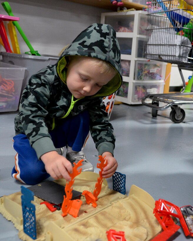 Easton McNelly, 3, son of Master Sgt. Rebecca McNelly, 90th Security Forces Group, plays with toys during the grand re-opening of the Airmen’s Attic on F.E. Warren Air Force Base, Wyo., Oct. 3, 2015. Rebecca McNelly is also the Air Force Sergeants Association’s president and volunteered during the attics grand reopening, assisting with visitors.