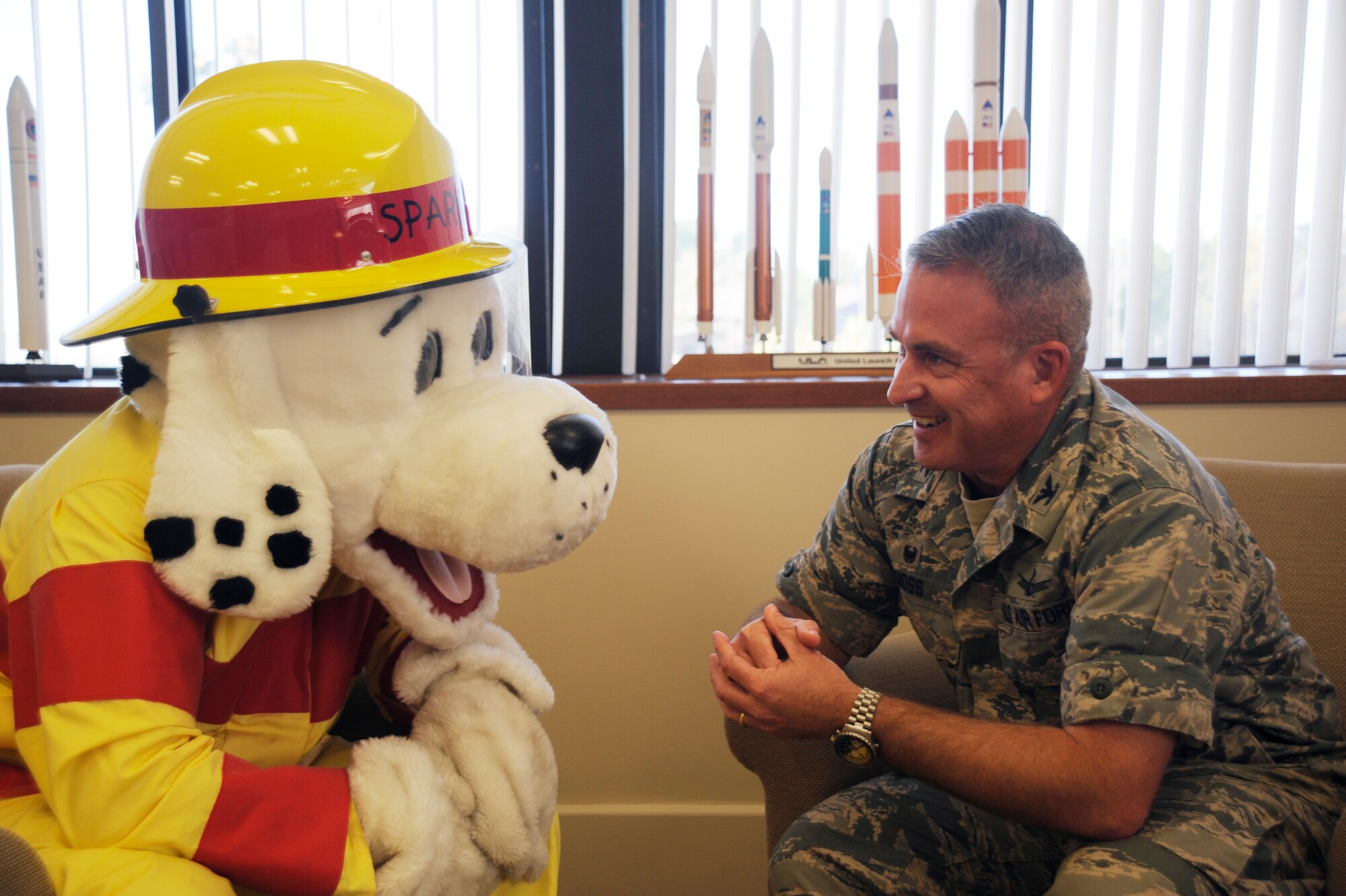 Col. Chris Moss, 30th Space Wing commander, and Sparky the Fire Dog discuss fire safety during Fire Prevention Week, Oct. 5, 2015, Vandenberg Air Force Base, Calif. Established to remember the great Chicago fire of 1871, which killed more than 250 people and burned more than 2,000 acres, National Fire Prevention Week has been observed nationwide since the first proclamation by President Woodrow Wilson in 1920. (U.S. Air Force photo by Airman 1st Class Ian Dudley/Released)
