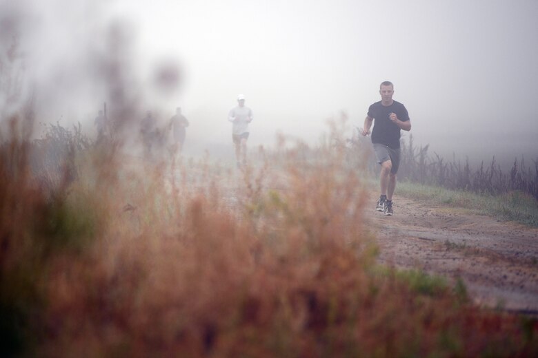 Runners emerge from the fog during the 10th annual half marathon Friday, Oct. 2, 2015, at Schriever Air Force Base, Colorado. Forty runners completed the 13.1 mile race in heavy fog, 12 mile per hour winds, mid-50s temperatures and mist. (U.S. Air Force photo/Christopher DeWitt)