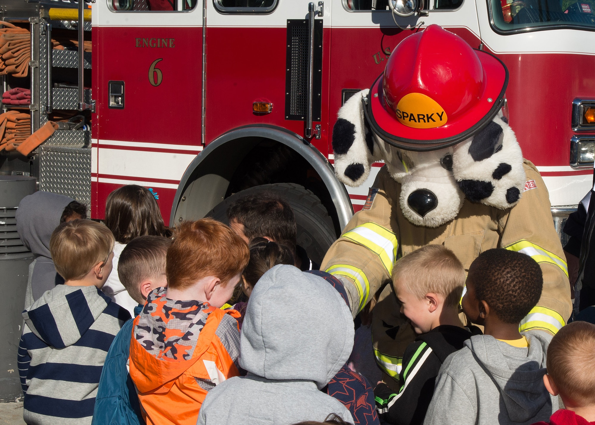 Sparky meets children outside the Child Development Center as part of a National Fire Prevention Week event Oct. 6. The theme for this year's weeklong event is: "Hear the Beep Where You Sleep: Every Bedroom Needs a Working Smoke Alarm!" (U.S. Air Force photo by Mark Herlihy)