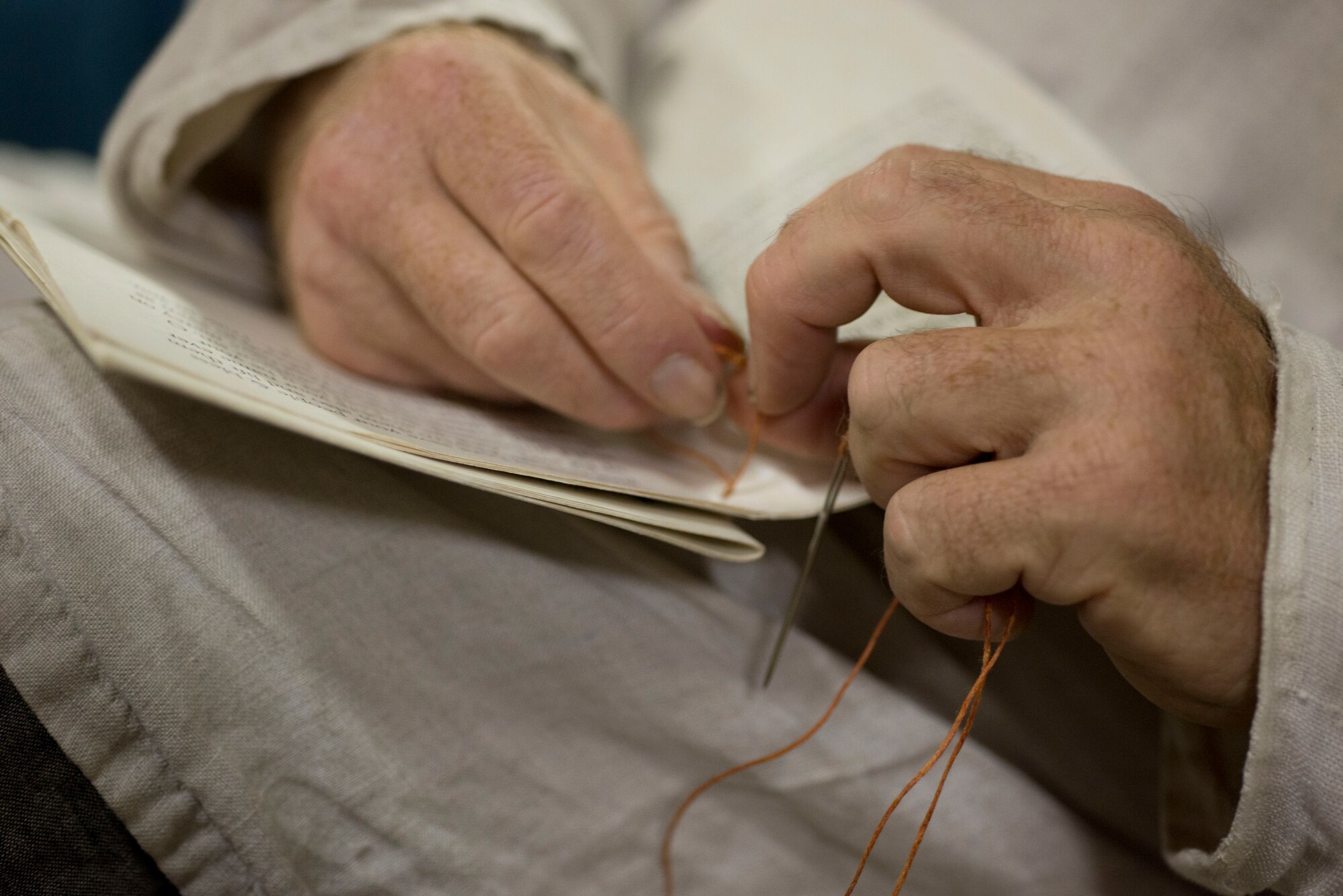 T.L. Watkins, artisan sews the binding of a book during Norsk Høstfest Military Appreciation Day in Minot N.D., Oct. 3, 2015. Watkins and his fellow artisans were one of many areas and displays Air Force members and their families were able to view. (U.S. Air Force photo/Senior Airman Stephanie Morris)