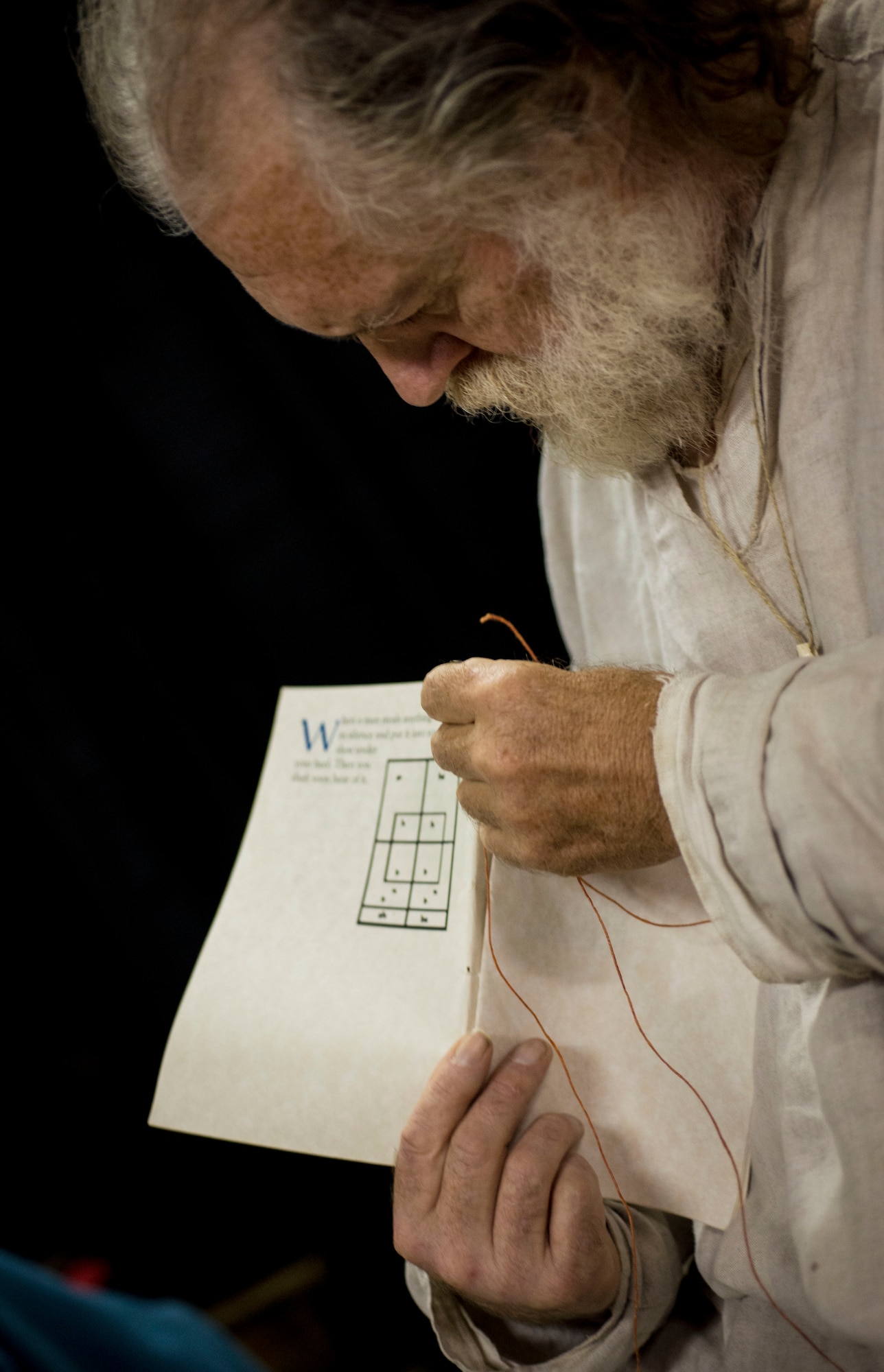 T.L. Watkins, artisan sews the binding of a book during Norsk Høstfest Military Appreciation Day in Minot N.D., Oct. 3, 2015. Watkins and his fellow artisans were one of many areas and displays Air Force members and their families were able to view. (U.S. Air Force photo/Senior Airman Stephanie Morris)