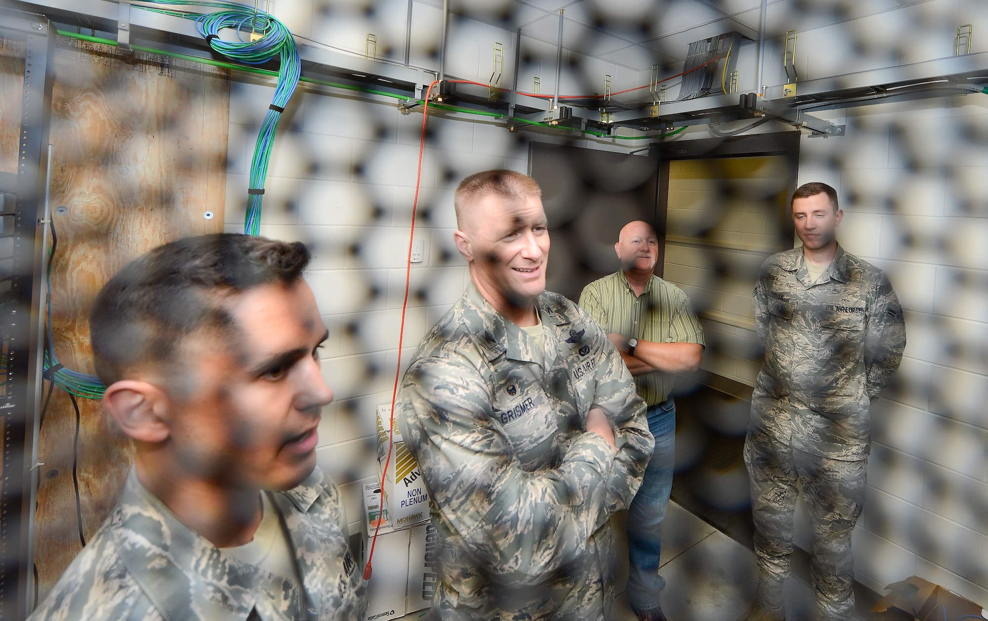 Col. Michael Grismer, 436th Airlift Wing commander, center, listens to Staff Sgt. Mark Smither, 436th Communications Squadron infrastructure technician, left, talk about the details of a secure server inside the 436th CS Sept. 30, 2015, at Dover Air Force Base, Del. Grismer learned about computer and telephone upgrades during his visit. (U.S. Air Force photo/Greg L. Davis)