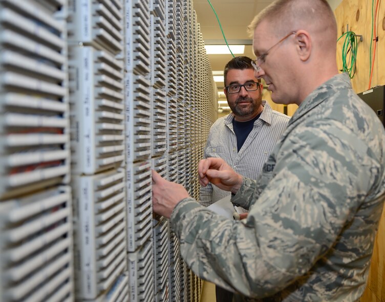 Col. Michael Grismer, 436th Airlift Wing commander, talks with Zane Tuxward, an Air Force contractor, while making new telephone line connections at the 436th Communications Squadron Sept. 30, 2015, at Dover Air Force Base, Del. Grismer learned how phone lines are established and also visited various work centers to learn about the unit???s mission. (U.S. Air Force photo/Greg L. Davis)