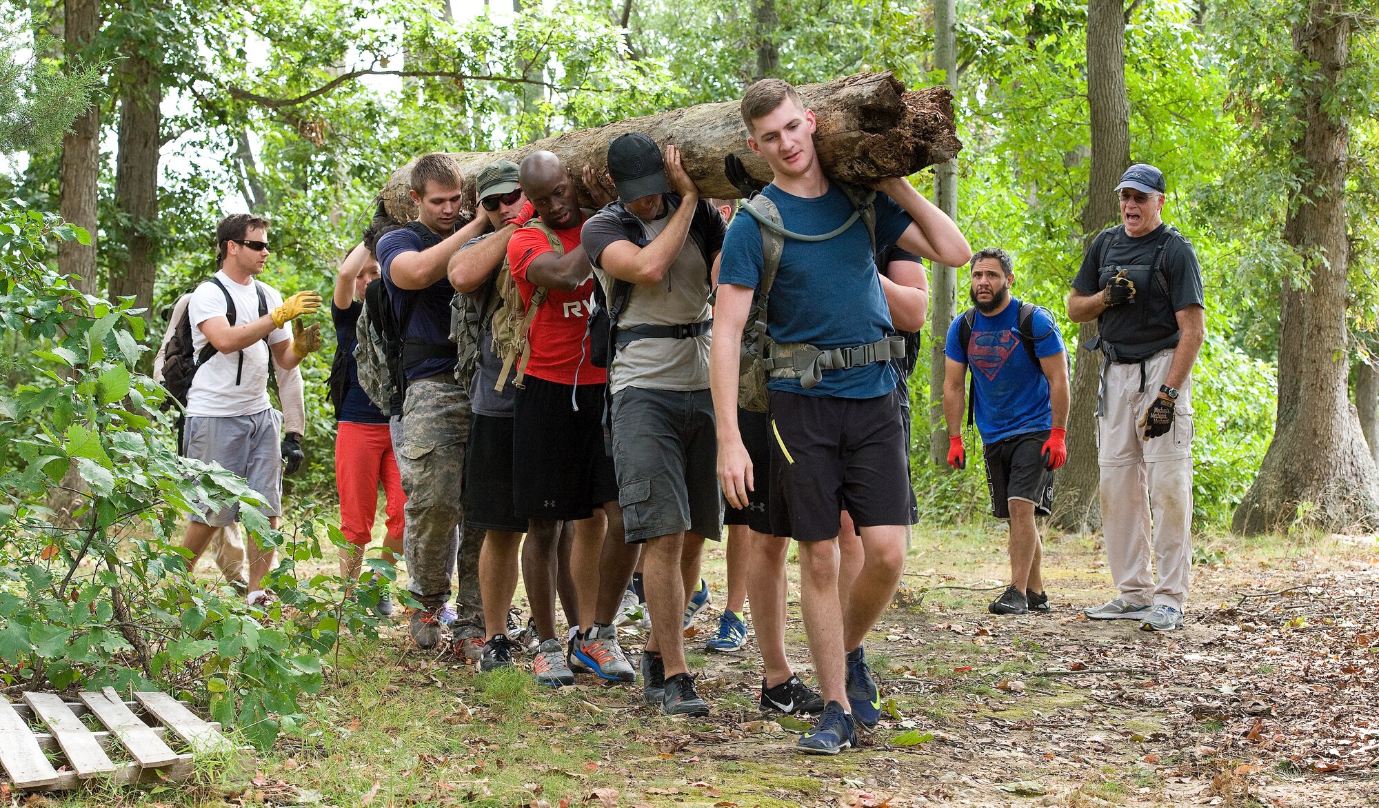 Master Sgt. Gary Porter, 512th Maintenance Squadron C-17 avionics intermediate maintenance section chief, calls out cadence to fellow GORUCK Light Team Dover members Sept. 25, 2015, on Dover Air Force Base, Del. Team members worked in unison to safely carry a heavy log more than a mile, one of many physical challenges participants endured. (U.S. Air Force photo/Roland Balik)