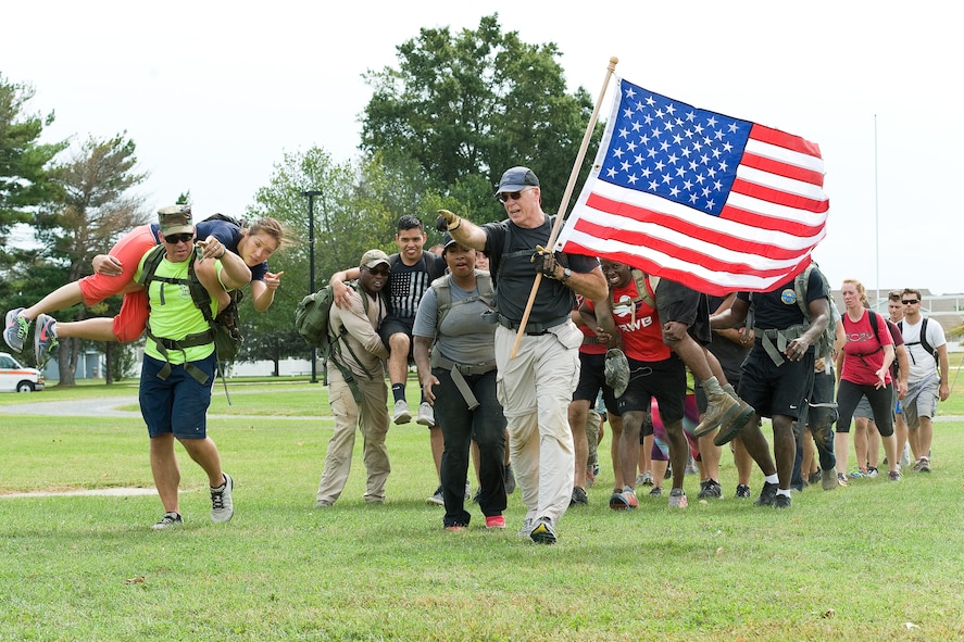 Master Sgt. Gary Porter, 512th Maintenance Squadron C-17 avionics intermediate maintenance section chief, carries the U.S. flag as he leads fellow GORUCK Light Team Dover members to a simulated extraction point Sept. 25, 2015, on Dover Air Force Base, Del. During the five-hour-long challenge led by a former U.S. Marine Corps reconnaissance member, participants completed numerous physical challenges along a 7.8-mile course and learned to overcome adversity by working as a team. (U.S. Air Force photo/Roland Balik)