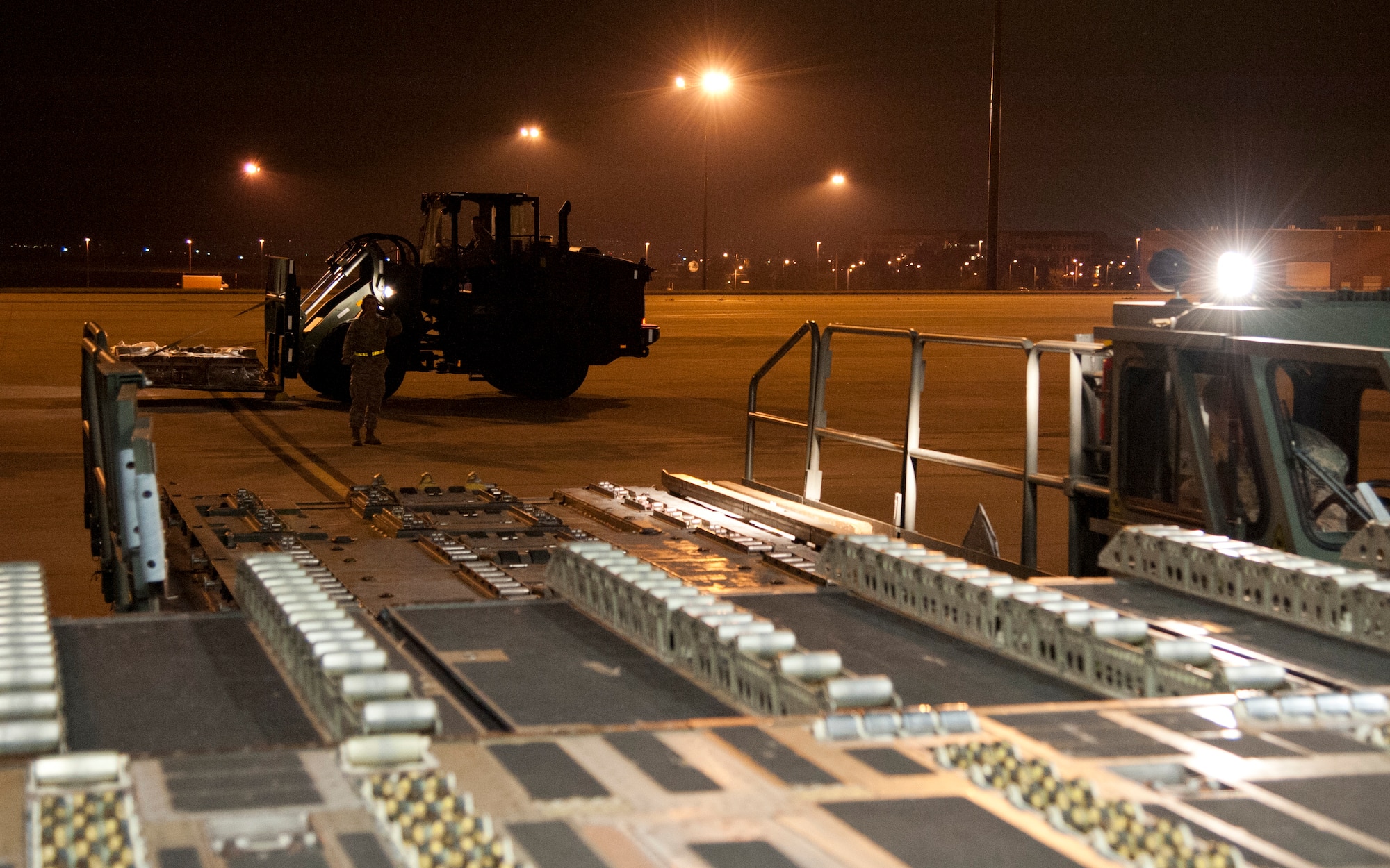 COLORADO SPRINGS, Colo. – Airmen from the 21st Logistics Readiness Squadron air terminal operations, operate loading equipment to load equipment on a C-17 Globemaster III from Travis Air Force Base, Calif., at the Arrival/Departure Airlift Control Group, Oct. 1, 2015. The 21st LRS air terminal team, Airmen from the 21st Airlift Squadron and Soldiers from the 10th Special Forces Group 3rd Battalion load the C-17 upon arrival in preparation for the Airmen and Soldiers’ next destination. (U.S. Air Force photo by Senior Airman Tiffany DeNault)