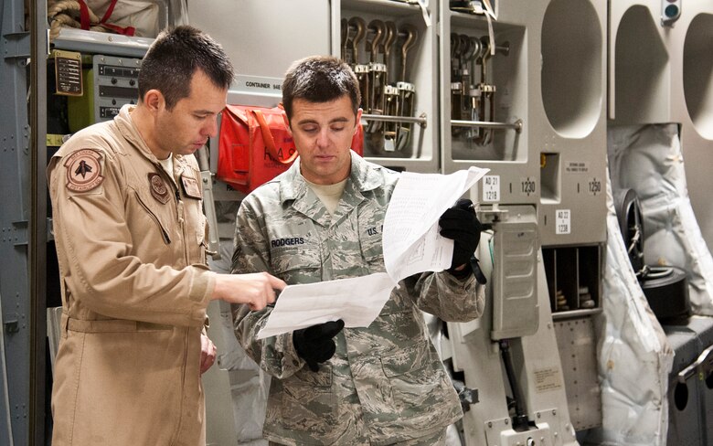 COLORADO SPRINGS, Colo. – Staff Sgt. Loydell Vestal II, 21st Airlift Squadron loadmaster and Staff Sgt. Ryan Rodgers, 21st Logistics Readiness Squadron air terminal operations supervisor, review the cargo load plan paperwork upon loading completion on a C-17 Globemaster III, from Travis Air Force Base, Calif., at the Arrival/Departure Airlift Control Group, Oct. 1, 2015.  Once the C-17 landed, it was taxied to the A/DACG where Rodgers, his team, Airmen from the 21st Airlift Squadron and Soldiers from 10th Special Force Group, 3rd Battalion waited to load the cargo. The 21st LRS air terminal team load and unload every deploying and returning Army and Air Force unit from Fort Carson and the surrounding military installation in the Pikes Peak region. (U.S. Air Force photo by Senior Airman Tiffany DeNault)
