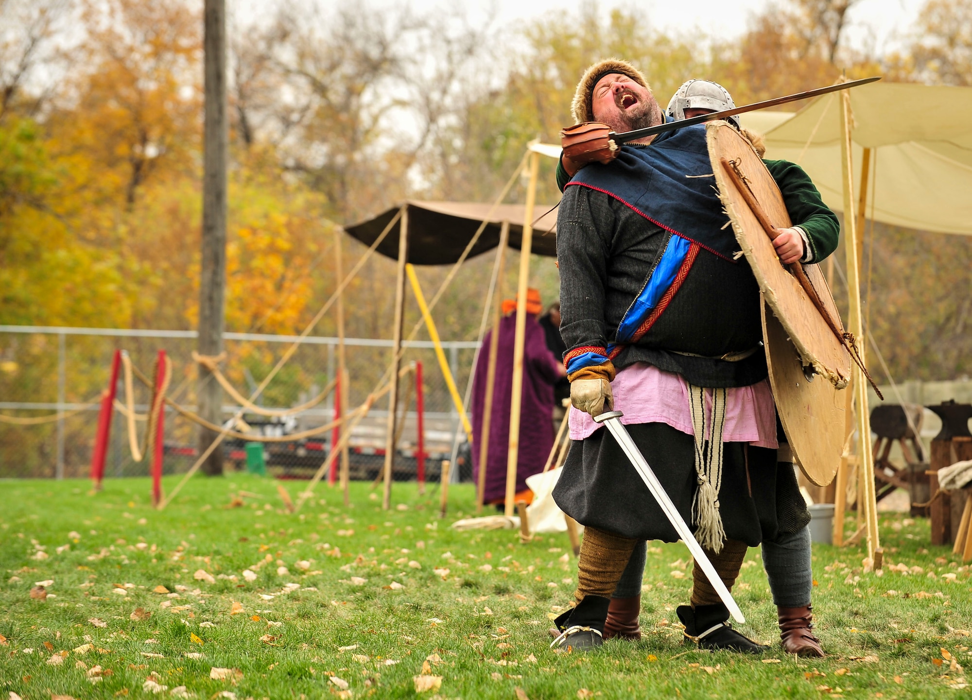 Sam Overland, Viking reenactor, pretends to be sleigh by another actor during Norsk Høstfest Military Appreciation Day in Minot N.D., Oct. 3, 2015. Overland and his fellow Vikings educated the crowd on Nordic battle customs and weaponry. (U.S. Air Force photo/Senior Airman Stephanie Morris)