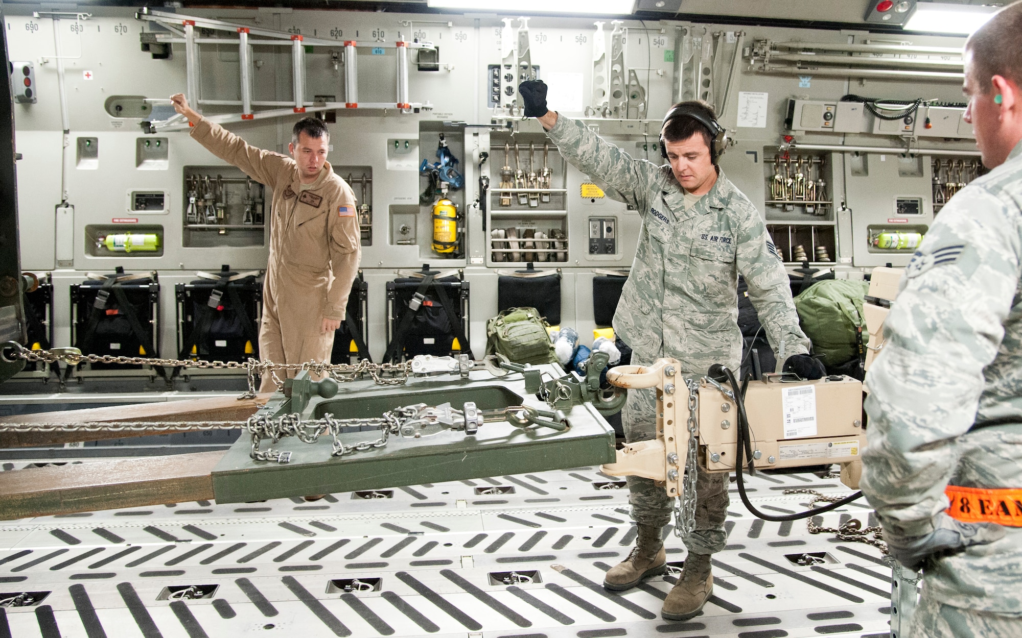 COLORADO SPRINGS, Colo. – Staff Sgt. Loydell Vestal II, 21st Airlift Squadron loadmaster and Staff Sgt. Ryan Rodgers, 21st Logistics Readiness Squadron air terminal operations supervisor, direct a forklift while loading a C-17 Globemaster III, from Travis Air Force Base, Calif., at the Arrival/Departure Airlift Control Group, Oct. 1, 2015.  The 21st LRS air terminal team prepares the load plan and cargo for every deploying and returning unit from Fort Carson. The team is also responsible for the Peterson passenger terminal and scheduling space-available flights for active duty and retired service members. (U.S. Air Force photo by Senior Airman Tiffany DeNault) 