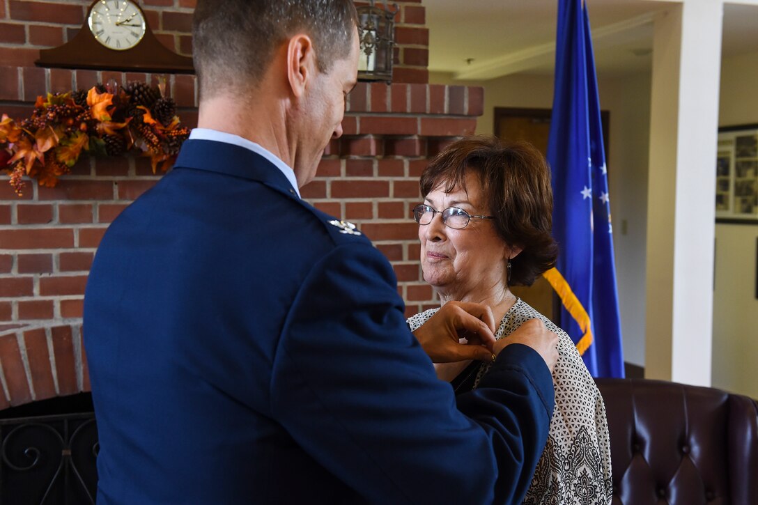 U.S. Air Force Col. Thomas Dorl, 347th Rescue Group commander, fastens a retirement pin on Ruth Treadwell, 347th RQG secretary, during her retirement ceremony Oct. 1, 2015, at Moody Air Force Base, Ga. Throughout her career, Ruth worked as a secretary for 30 squadron commanders, 20 executive officers, and 10 group commanders. (U.S. Air Force photo by Senior Airman Ceaira Tinsley/Released)
