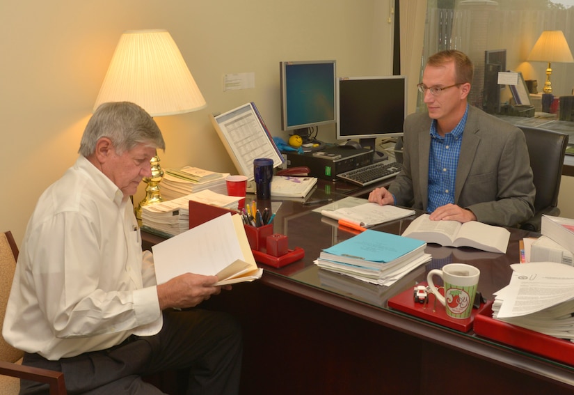(From left to right) Mike Peterson, 628th Air Base Wing Equal Opportunity director, sits with Jon Stanley, 628th ABW Civil Law division chief in the Civil Law office on Joint Base Charleston – Air Base, S.C., Oct. 2, 2015. Peterson and Stanley were discussing  a mediation settlement agreement concerning the base. (U.S. Air Force photo/Airman 1st Class Thomas T. Charlton)