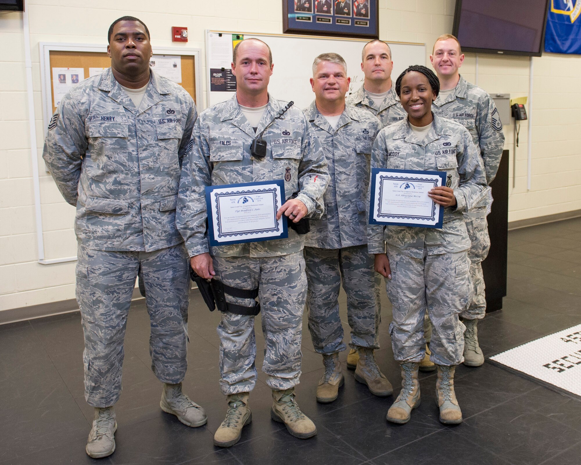 Members of the Space Coast Top-3 Association present Tech. Sgt. Bradford Fales (June winner) and Senior Airman Khrystyna McCoy, (July winner) both of 45th Security Forces Squadron, with a superior performer award, Sept. 29, 2015, at Patrick Air Force Base, Fla., during their guard mount duty. The two Airmen were recognized for exemplary duty performance, self-improvement initiatives and community involvement. Additionally, the Airmen were coined and given a two-night complementary stay at a hotel in Cocoa Beach, Fla. (U.S. Air Force photo/Matthew Jurgens/Released)   