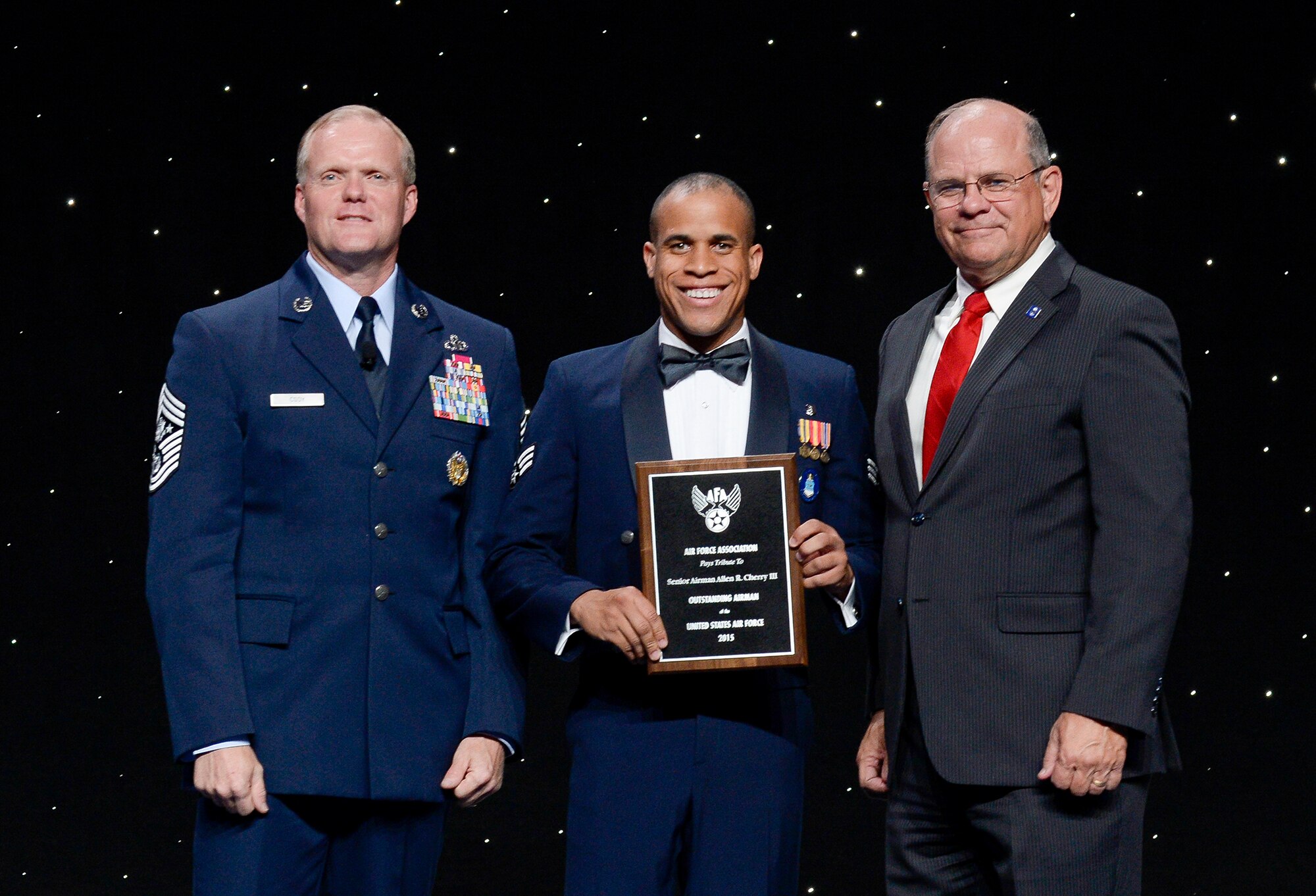 Chief Master Sergeant of the Air Force James Cody and Air Force Association Vice Chairman of the Board Scott Van Cleef flank Senior Airman Allen Cherry at an award ceremony during which Cherry is officially honored as a member of the 12 Outstanding Airmen of the Year, National Harbor, Md, September 14, 2015. (Air Force photo Andy Morataya)