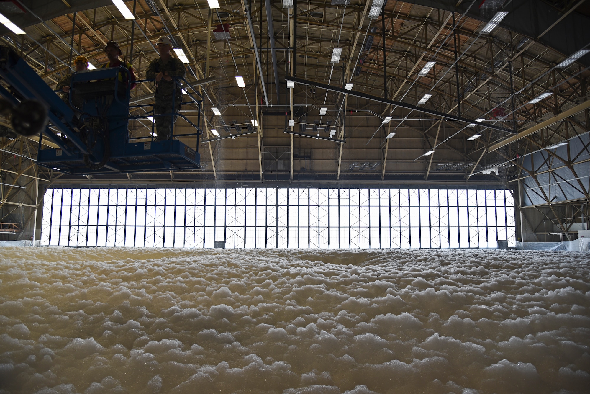 The 92nd Civil Engineer Squadron, maintainers, emergency responders and local contractors complete the foam suppression test in hangar one Oct. 1, 2015, at Fairchild Air Force Base, Wash. The test ran for approximately two and a half minutes creating over six feet of foam which covered the entire hangar floor, 68,000 square feet. (U.S. Air Force photo/Airman 1st Class Mackenzie Richardson)