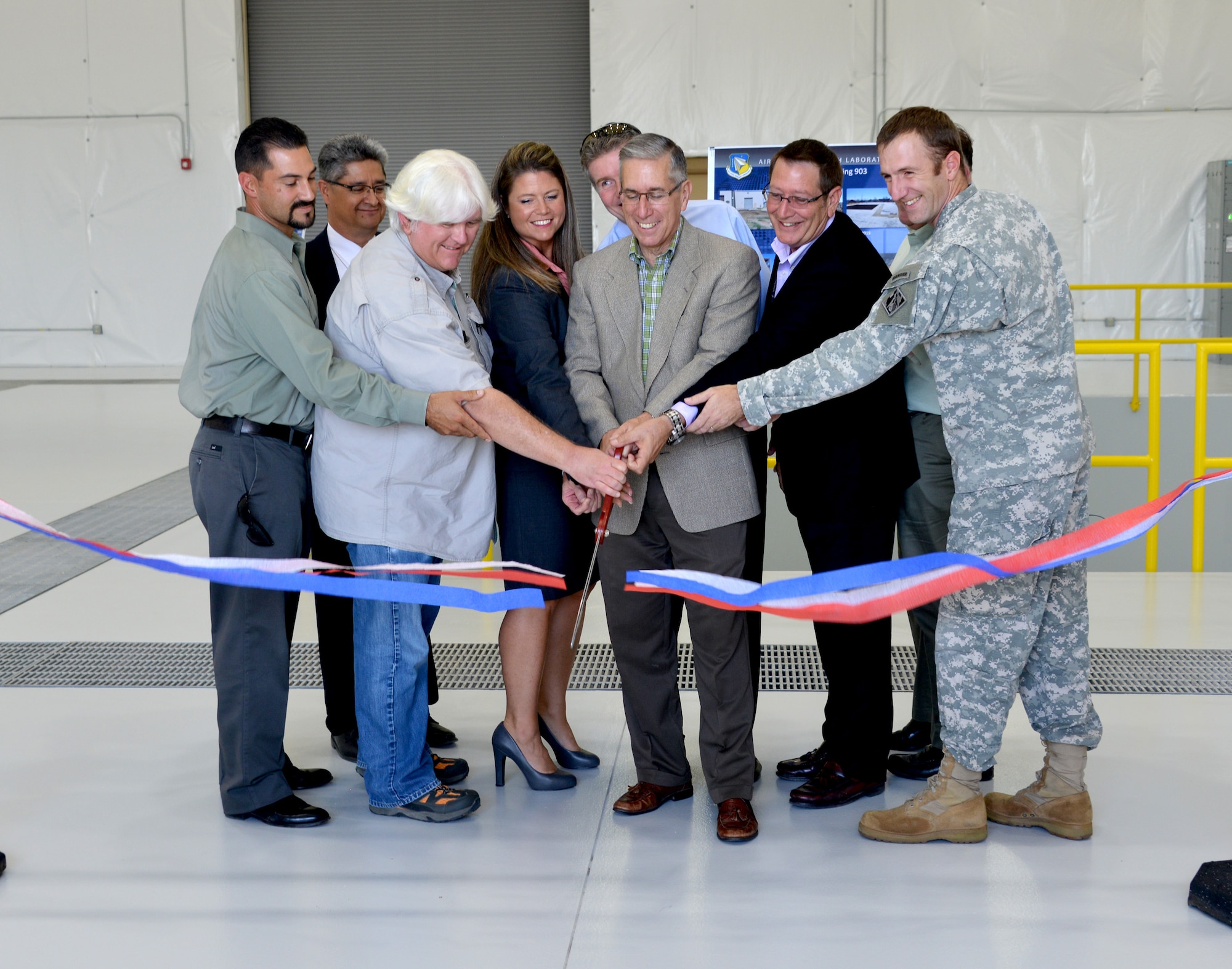 David Hardy, in the light-colored jacket at center, former Air Force Research Laboratory Directed Energy Directorate director, and other dignitaries cut a ribbon to open a new building Sept. 22. The facility will be the site of AFRL’s high-powered electromagnetic systems testing at Kirtland. (Photo by Dennis Carlson)
