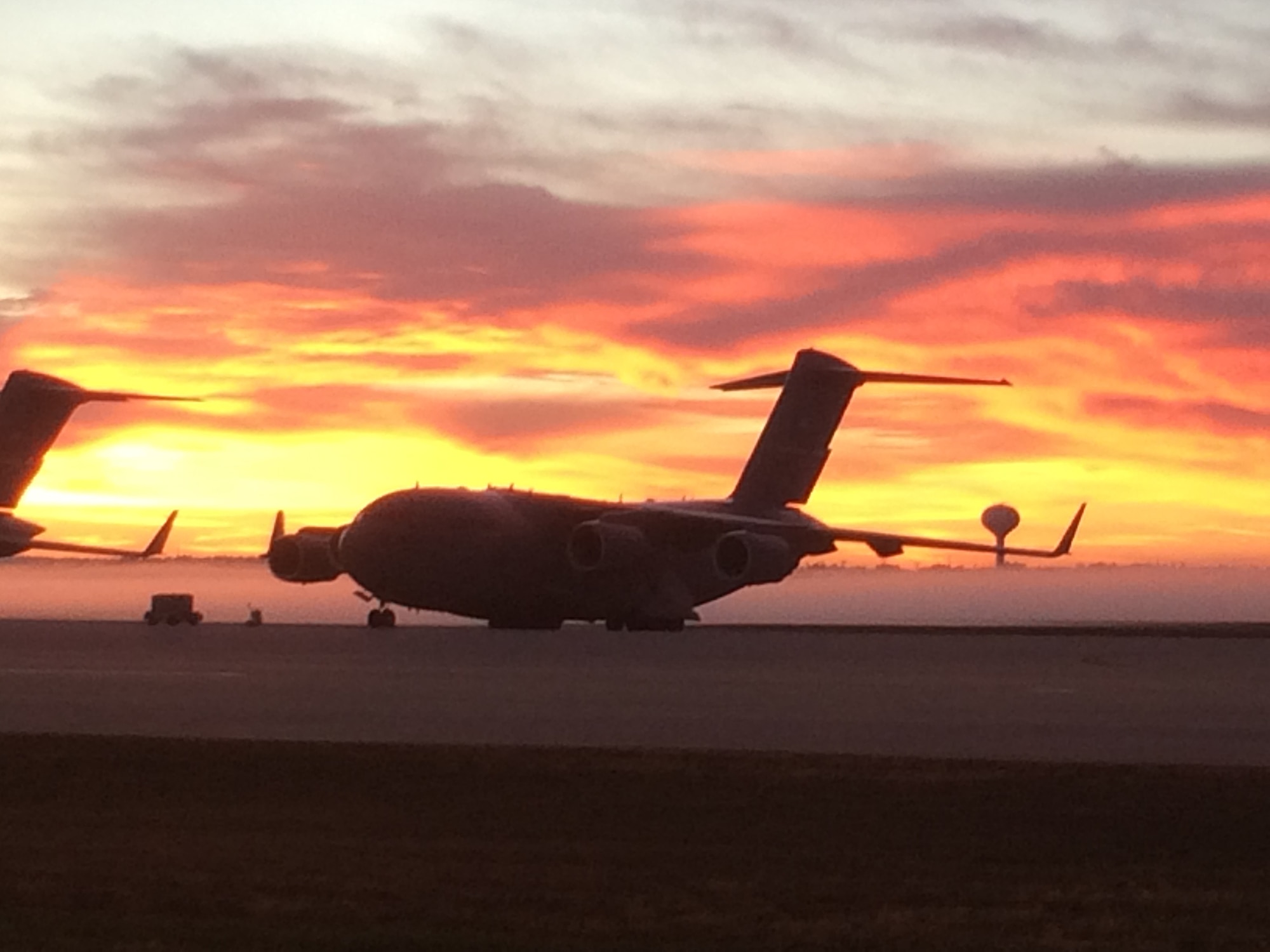 WRIGHT-PATTERSON AIR FORCE BASE, Ohio – The early morning sunrise and background fog highlights a 445th Airlift Wing C-17 Globemaster III sitting on the ramp at Wright-Patterson Air Force Base, Ohio Oct. 6, 2015. The fall temperature mixed with moisture in the air caused a blanket of fog to highlight the beauty of the aircraft. (U.S. Air Force photo/Master Sgt. Brock Felgenhauer)