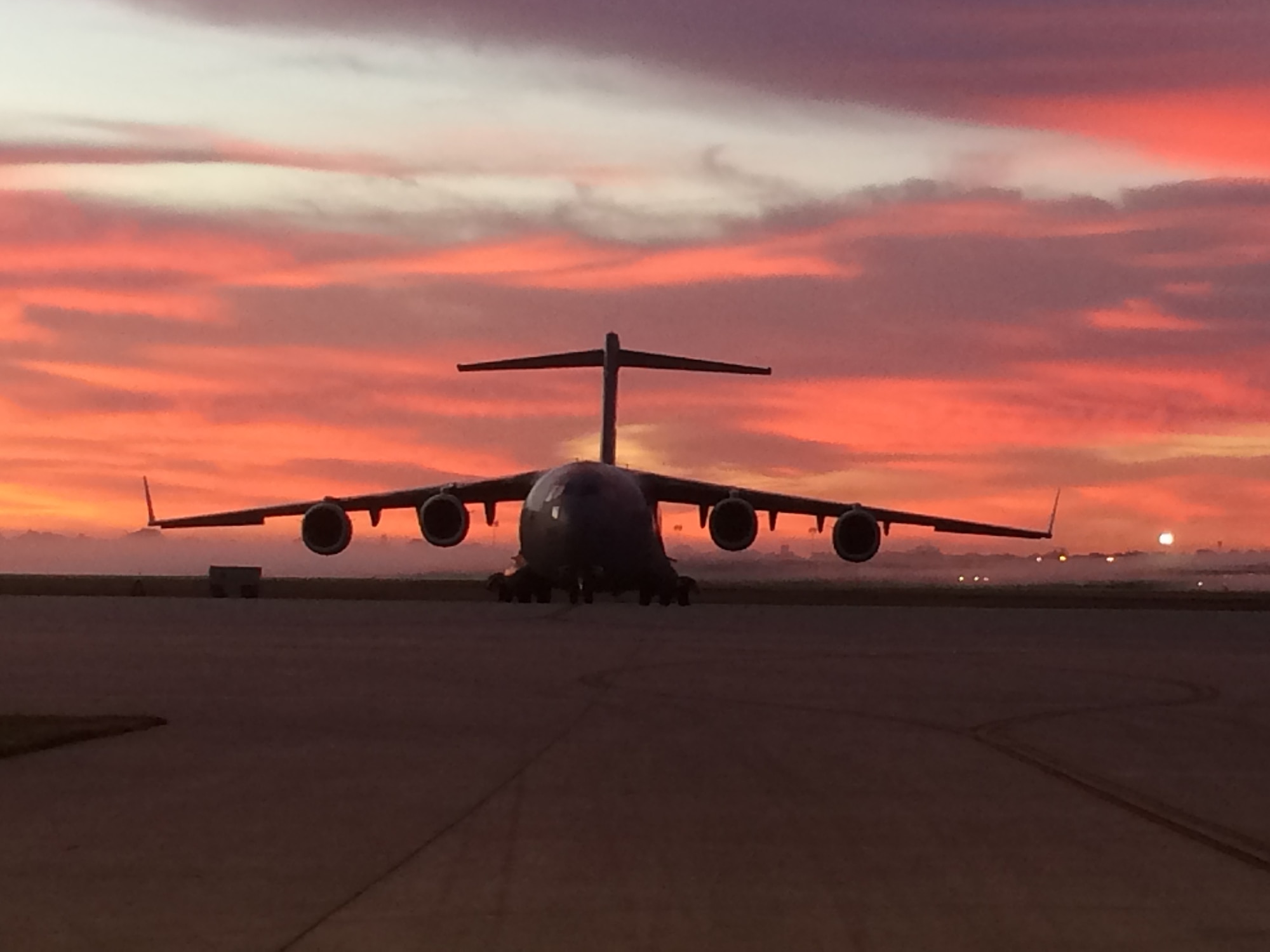 WRIGHT-PATTERSON AIR FORCE BASE, Ohio – The early morning sunrise and background fog highlights a 445th Airlift Wing C-17 Globemaster III sitting on the ramp at Wright-Patterson Air Force Base, Ohio Oct. 6, 2015. The fall temperature mixed with moisture in the air caused a blanket of fog to highlight the beauty of the aircraft. (U.S. Air Force photo/Master Sgt. Brock Felgenhauer)