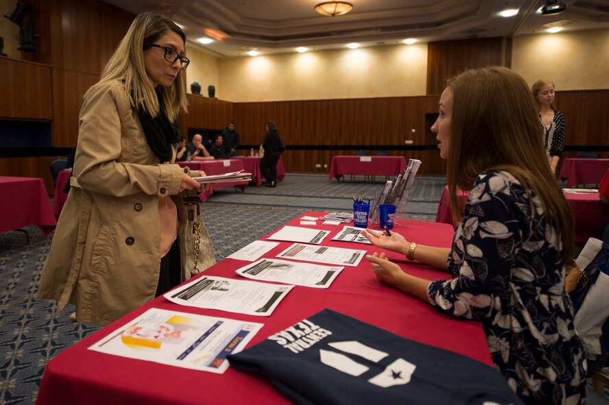 Desiree Herndon, wife of U.S. Air Force Staff Sgt. Dillon Herndon, 52nd Component Maintenance Squadron jet engine intermediate maintenance crew supervisor, talks to a representative of a base educational institution during a job fair at Club Eifel on Spangdahlem Air Base, Germany, Oct. 6, 2015. The job fair was a forum for base agencies to inform the community of job opportunities. (U.S. Air Force photo by Staff Sgt. Christopher Ruano/Released)

