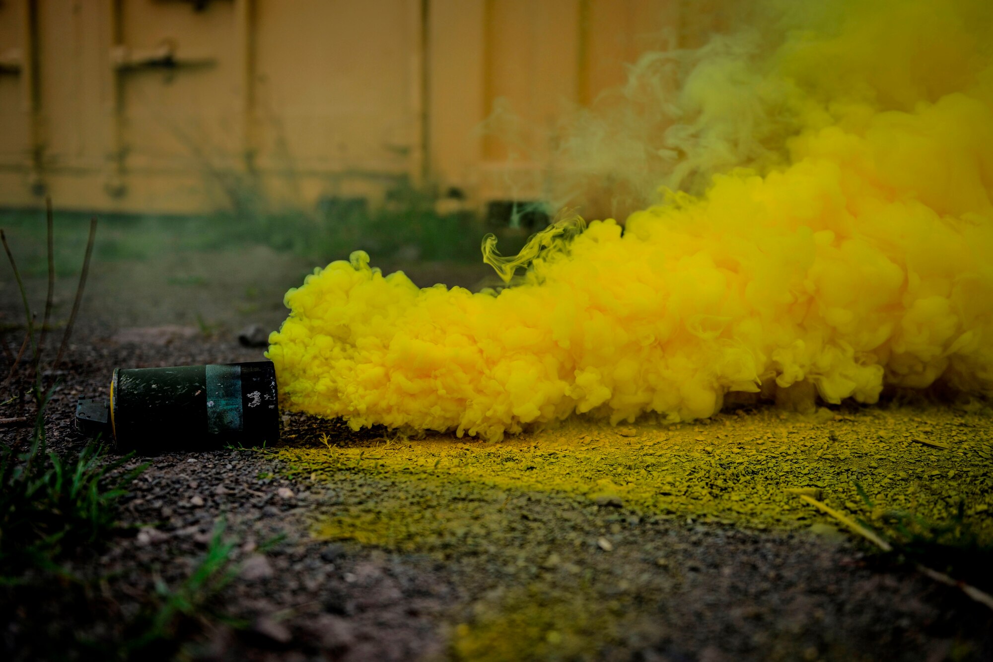 A smoke grenade sprays yellow smoke during a Creek Defender field training exercise Sept. 26, 2015, on Baumholder, Germany.  Smoke was used during the exercise to add stress to the environment and test security forces members on their skills to respond to a chaotic situation in a deployed environment. (U.S. Air Force photo/Senior Airman Nicole Sikorski)
