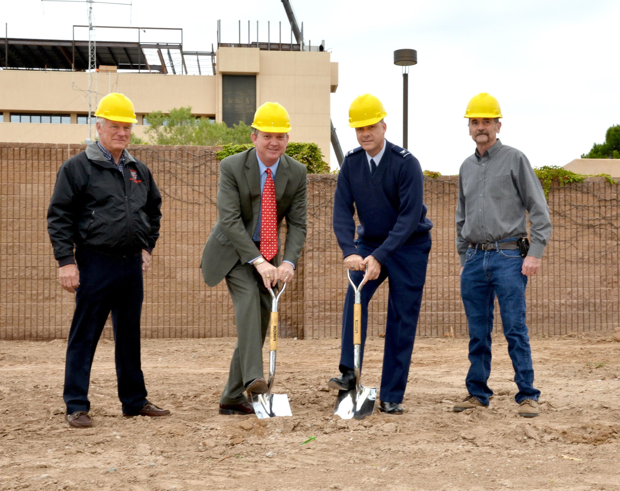 Andrew Welch, New Mexico Veterans Affairs Health Care System director, and Col. Jeffrey White, 377th Medical Group commander, don hard hats and take shovels to break ground for a new, eight-bed sleep disorder center. Supervising is Bill Lawrence (left), VA's project manager for the construction, and Dick Hart, 377th MDG facility chief. (Photo by Jamie Burnett)
