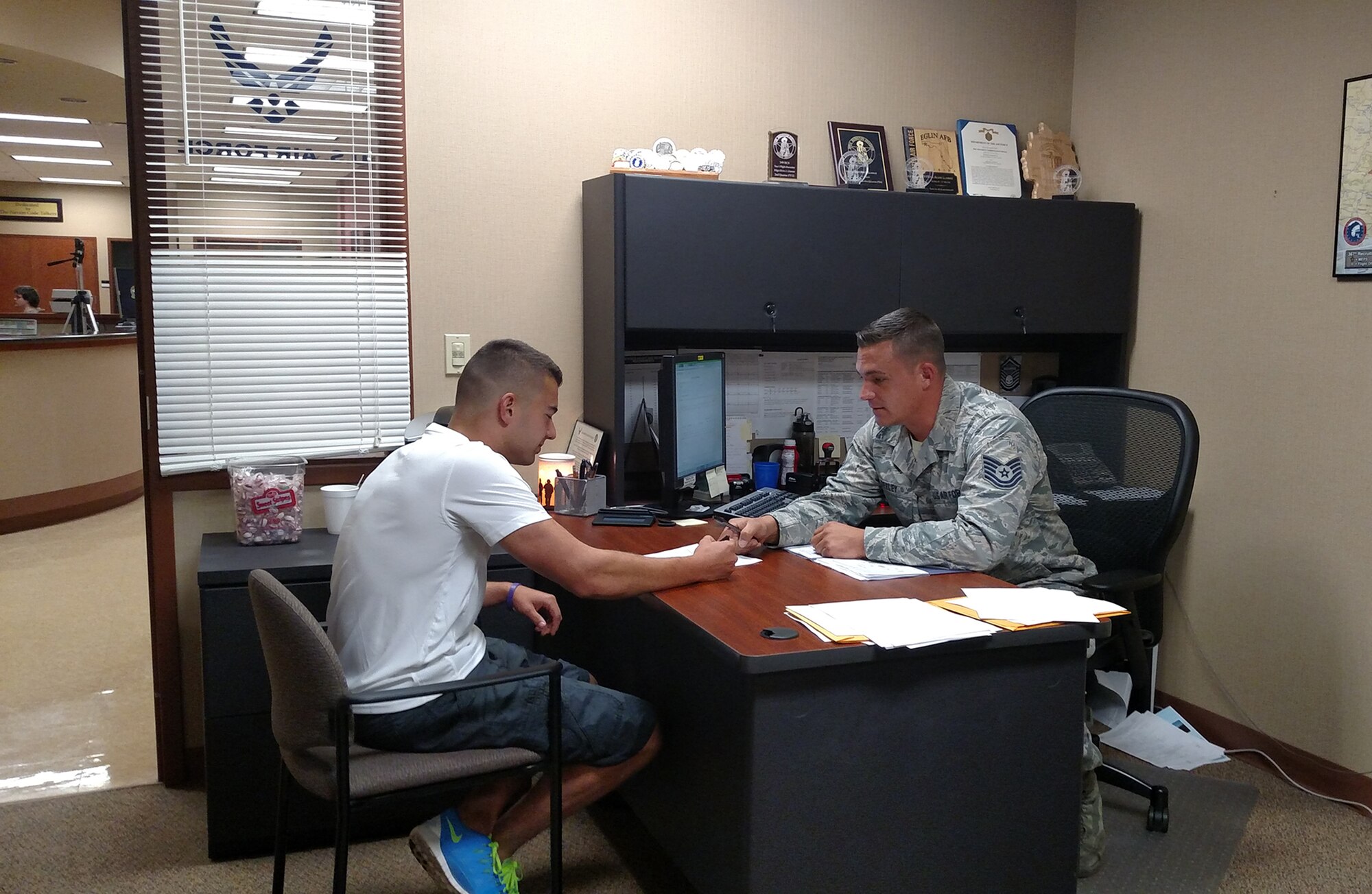 Tech. Sgt. Greg Seeley, 367th Recruiting Squadron, briefs a new member of the Delayed Entry Program at the Albuquerque Military Entrance Processing Station. (U.S. Air Force photo)