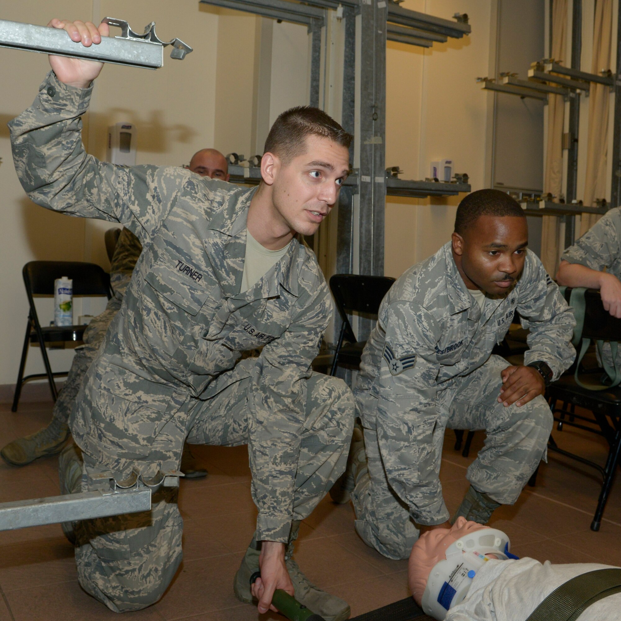 Senior Airman Dalton Turner (left), 39th Medical Operations Squadron information system technician, and Senior Airman David Westbook, 39th Medical Support Squadron bioenvironmental engineering technician, practice loading a litter onto a stanchion Sept. 30, 2015, at Incirlik Air Base, Turkey. Airmen from the 39th Medical Group held a training day to review and practice work-center specific competencies. (U.S. Air Force photo by Senior Airman Krystal Ardrey)