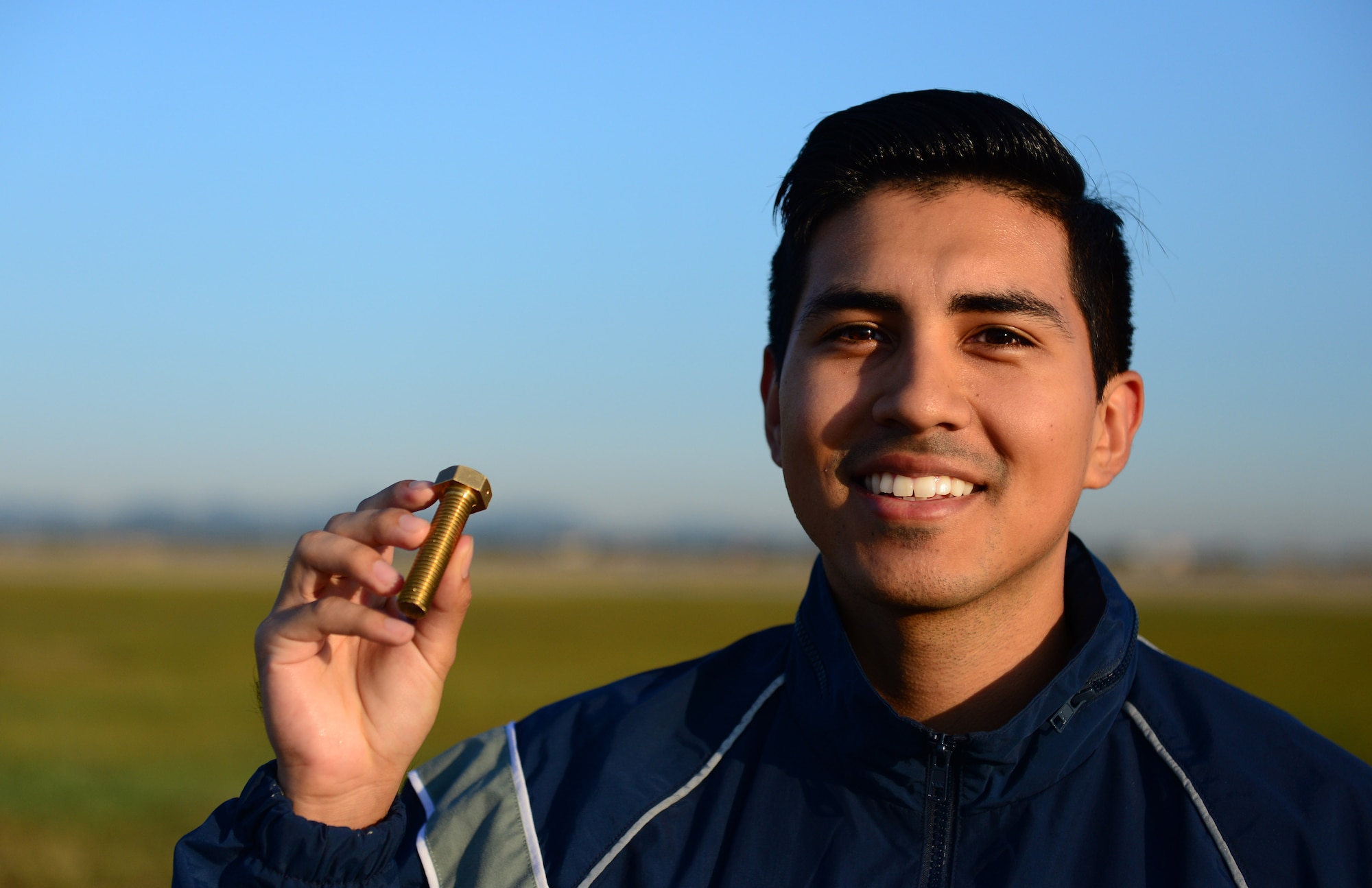 Airman 1st Class Rafael Daniel, 51st Communications Squadron knowledge operator, displays the “golden bolt” found during the foreign-object-debris walk performed across the airfield of Osan Air Base, Republic of Korea, Sept. 29, 2015. Four golden bolts were hidden along the flightline as an added incentive, the finder of one these bolts would earn a day off. 
(U.S. Air Force photo/Staff Sgt. Amber Grimm)