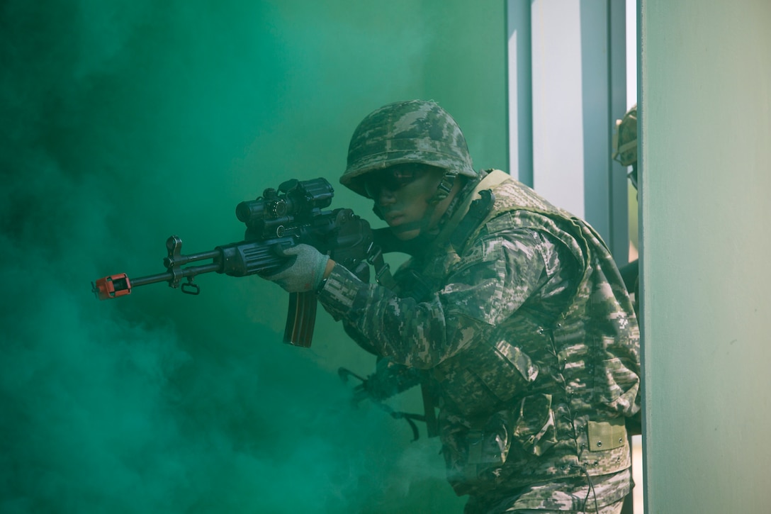 Republic of Korea Marine Cpl. Geon Shin breaches a building alongside U.S. Marines under smoke concealment during Korean Marine Exchange Program 15-12 at Gunha-Rhi, Gimpo, Republic of Korea, Sept. 17, 2015. KMEP 15-12 is a bilateral training exercise that enhances the ROK and U.S. alliance, promotes stability on the Korean Peninsula and strengthens ROK and U.S. military capabilities and interoperability. Shin, from Mokpo, ROK, is a rifleman with 1st Company, 11th Battalion, 1st Regiment, 2nd Marine Division. The U.S. Marines are with Fox Company, 2nd Battalion, 3rd Marine Regiment, currently assigned to 4th Marine Regiment, 3rd Marine Division, III Marine Expeditionary Force under the unit deployment program.