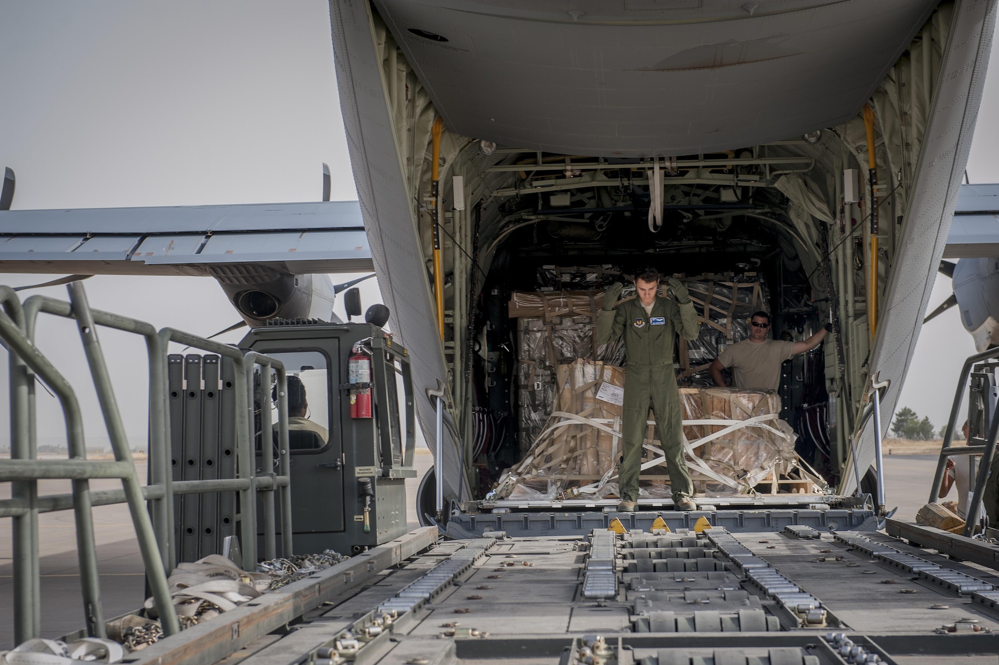 Senior Airman Dustin Dixon, a 435th Contingency Response Squadron loadmaster, directs an aircraft loader during a C-130J Super Hercules off-load of equipment Sept. 12, 2015, at Diyarbakir Air Base, Turkey. Airmen from the 435th Contingency Response Group received more than 680 tons of equipment for base operations in support of the U.S. Air Force’s support personnel recovery mission from Turkey. When requested, coalition aircraft and personnel will provide recovery capability to protect and recover coalition members. (U.S. Air Force photo/Airman Cory W. Bush)