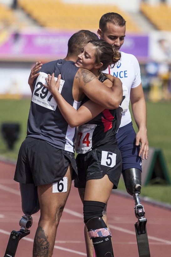 U.S. track athlete Elizabeth Wasil, center, and Peru athlete Carlos Felipa Cordova hug after their 200-meter Para race during the 6th Military World Games in Mungyeong, South Korea, Oct. 7, 2015. U.S. Marine Corps photo by Cpl. Jordan E. Gilbert