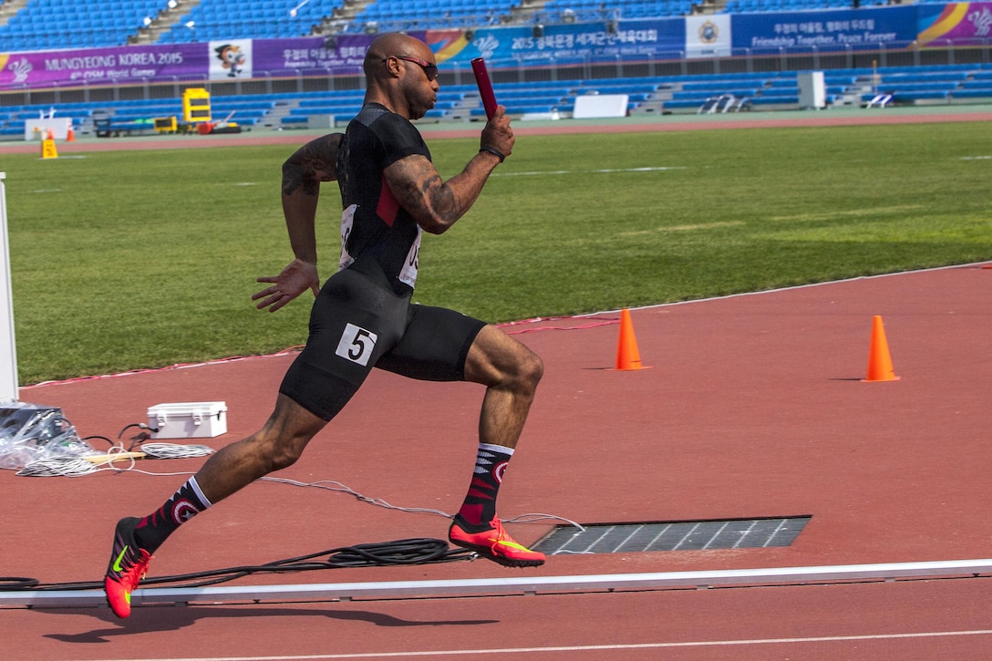 A U.S. track athlete carries the baton during the Men’s 4x400-meter relay race during the 6th CISM Military World Games in Mungyeong, South Korea, Oct. 7, 2015. U.S. Marine Corps photo by Sgt. Ashley N.Cano