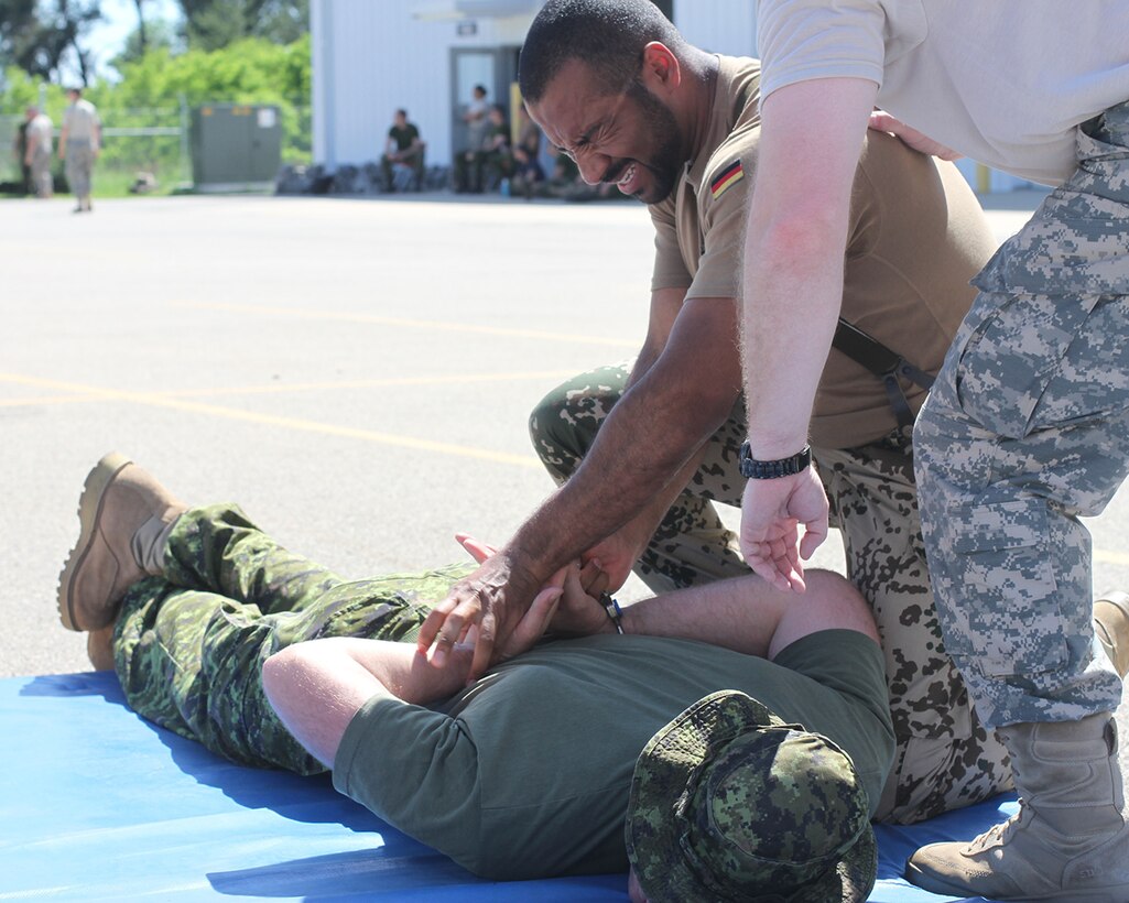 German army officer Capt. Nana Baidoo, from the 12th Military Police Regiment, is attempting to control a subject after being sprayed with Oleoresin Capsicum Spray (OC) as a part of the Operation Guardian Justice 200th Military Police Command Training in Fort MoCoy, Wis., June 7, 2015. (U.S. Army Reserve photo by Spc. Stephanie Ramirez/Released)