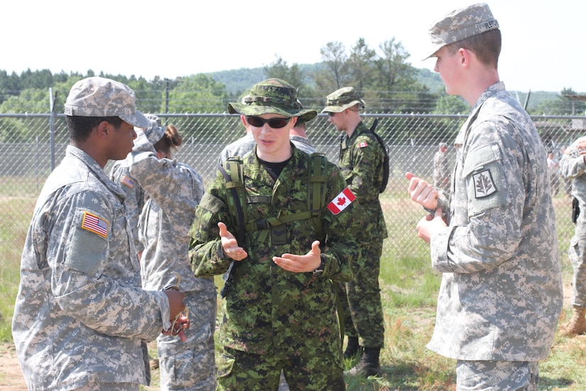 U.S. Army Reserve and Canadian soldiers discuss their distinctive detainee operations procedures before beginning the practical training during Operation Guardian Justice in Fort McCoy, Wis., June 9, 2015. (U.S. Army Reserve Photo by Spc. Stephanie Ramirez/Released)