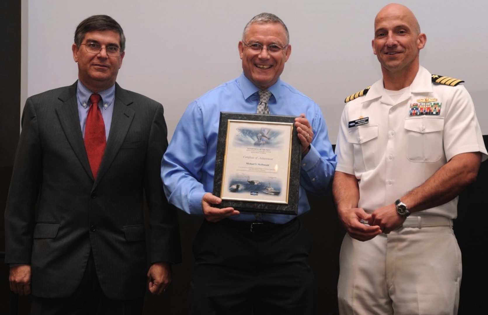 DAHLGREN, Va. - Mike McDonald receives his certificate of achievement from Naval Surface Warfare Center Dahlgren Division (NSWCDD) Technical Director Dennis McLaughlin and NSWCDD Commanding Officer Capt. Brian Durant at the annual command academic awards ceremony, Sept. 21. The NSWCDD engineer - and his wife, Janette Calo - were recognized for completing a master's degree in systems engineering  and commended for commitment to their personal and professional development. 