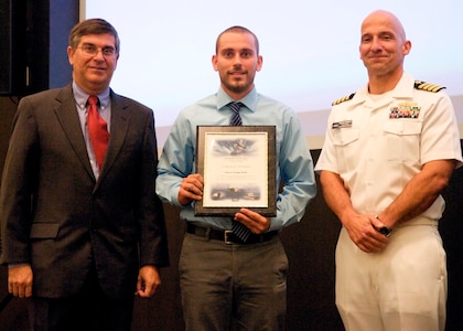 DAHLGREN, Va. - Drew Mohle receives his certificate of achievement from Naval Surface Warfare Center Dahlgren Division (NSWCDD) Technical Director Dennis McLaughlin and NSWCDD Commanding Officer Capt. Brian Durant at the annual command academic awards ceremony, Sept. 21. The NSWCDD engineer - and his wife, Abby - were recognized for completing a master's degree in systems engineering and commended for commitment to their personal and professional development.  