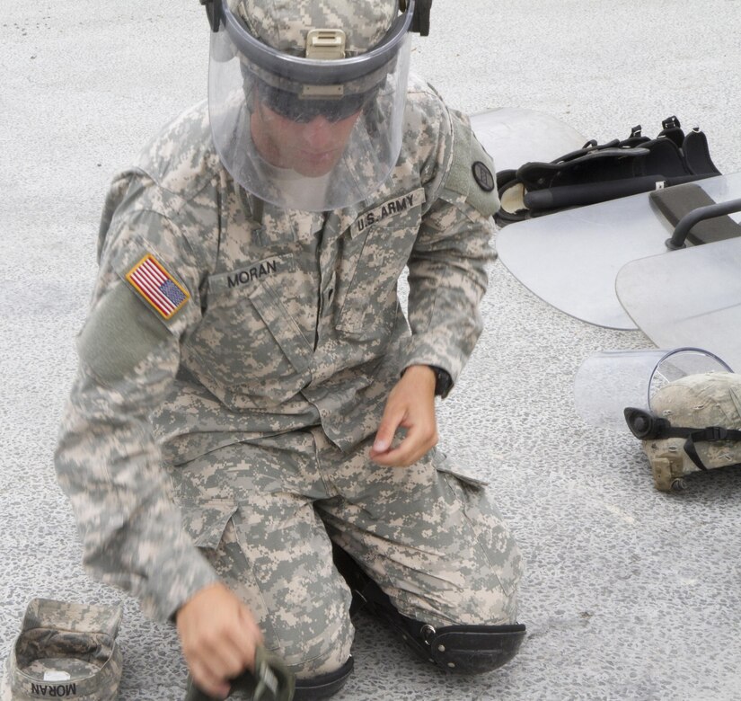 Spc. Andrew Moran, from the 1st Battalion, 252nd Armor Regiment’s Alpha Company, prepares to put on his protective gear for crowd and riot control training June 15 at the Joint Multinational Readiness Center in Hohenfels, Germany. The training is being conducted in preparation for a peacekeeping mission in Kosovo.