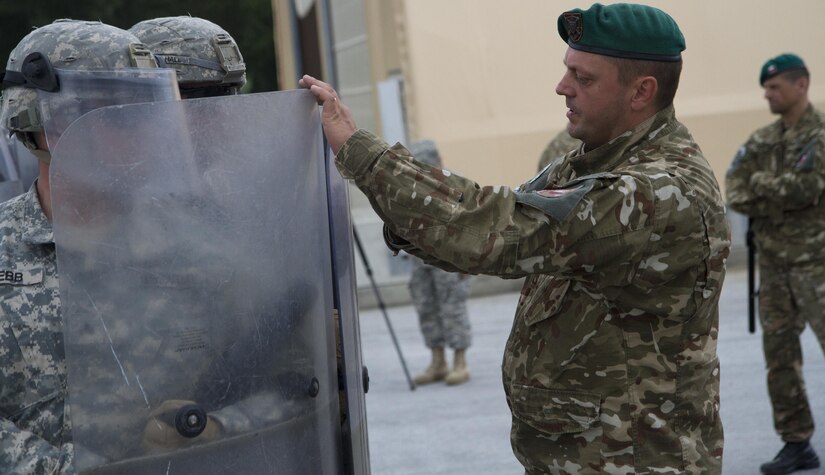 A soldier from the Slovenian armed forces military police instructs U.S. Soldiers from the 1st Battalion, 252nd Armor Regiment, during crowd and riot control training June 15 at the Joint Multinational Readiness Center in Hohenfels, Germany. The training is being conducted in preparation for a peacekeeping mission in Kosovo.