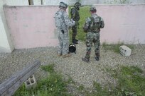 The 666th EOD Company from Jacksonville, Ala., performs various training techniques with the Moldovan army in the counter improvised explosive device training area June 21 at the Joint Multinational Readiness Training Center in Hohenfels, Germany. The purpose of the training is to make sure all EOD techs sharpen their individual skills as they prepare for real-world missions in Kosovo. One of the techniques used is designed so the techs can limit the contact involved when dealing with an explosive device. (U.S. Army Photo by Sgt. Erick Yates)