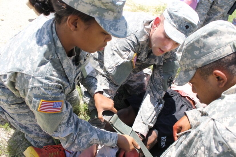 Spc. Travanda Burton, an information technology specialist with the 345th Combat Support Hospital, assists Spc. Aaron Smith, a licensed practical nurse also with the 345th, secure an injured Soldier in a mass casualty training exercise June 3 at Fort Hood, Texas. The exercise was conducted for pre-mobilization training before leaving on a peacekeeping mission to Kosovo. (U.S. Army photo by Sgt. Erick Yates)