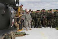 Sgt. David Allen, a flight medic, and Staff Sgt. Christopher Lance, a team leader in charge of training for 345th Combat Support Hospital, demonstrate how to use the hoist device during medical evacuation procedures at the Joint Multinational Readiness Center in Hohenfels, Germany, June 19. Troops from the Romanian Army’s 26th Mountain Battalion also took part in the training. (U.S. Army photo by Sgt. Erick Yates)