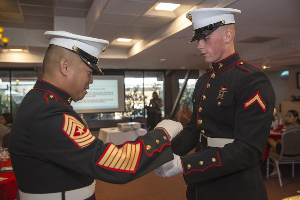 Pfc. Bronson Hicks, student, Marine Corps Communication-Electronics School, passes the birthday cake to Combat Center Sergeant Major, Sgt. Maj. Karl Villalino, during a demonstration birthday ball ceremony as part of the Belle of the Ball event at the Combat Center Officer’s Club, Oct. 3, 2015. (Official Marine Corps photo by Lance Cpl. Levi Schultz/Released)