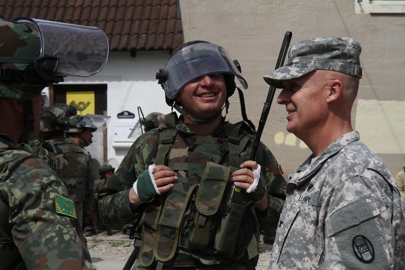 Capt. Saijmir Germenji, commander for the Albanian Army 2nd Infantry Company, greets Col. Vernon Simpson, commander of the 30th Armored Brigade Combat Team, after completing training in a multinational exercise that included forces from the U.S., Albania and Moldova for crowd and riot control June 25 in Hohenfels, Germany. The 30th ABCT, an Army National Guard Unit from North Carolina, participated in this training event in preparation for a peacekeeping mission in Kosovo. (U.S. Army Photo by Sgt. Erick Yates)