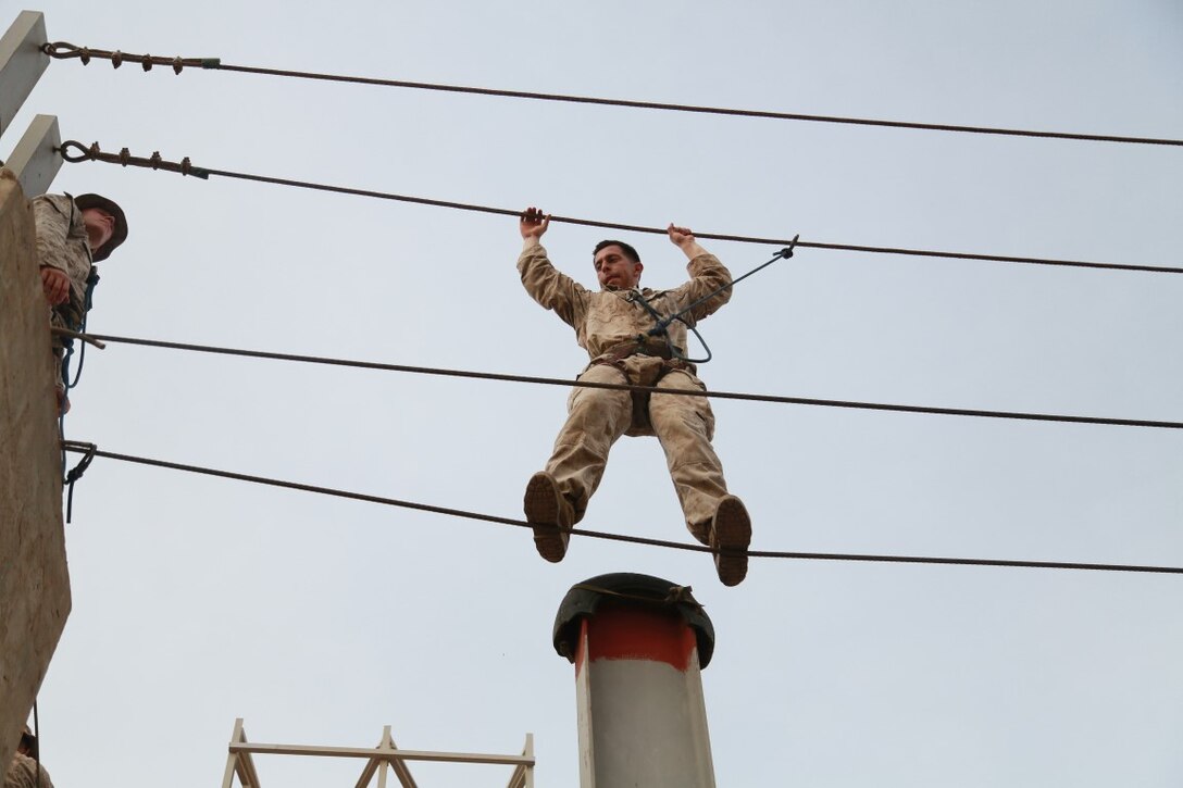 A U.S. Marine from the 15th Marine Expeditionary Unit makes his way across an obstacle during a portion of a desert survival course with the French 5th Overseas Combined Arms Regiment (RIAOM). Elements of the 15th MEU are training with the 5th RIAOM in Djibouti in order to improve interoperability between the MEU and the French military. (U.S. Marine Corps photo by Sgt. Steve H. Lopez/Released)