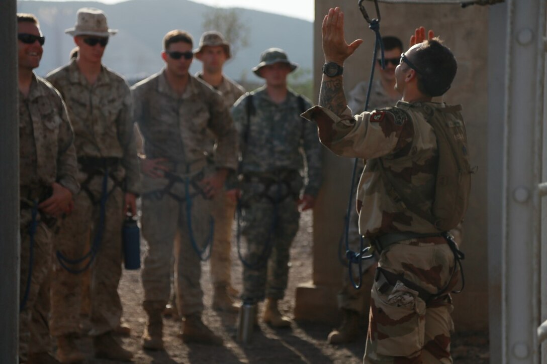 ARTA BEACH, Djibouti (Sept. 25, 2015) An instructor from the French 5th Overseas Combined Arms Regiment (RIAOM) demonstrates how to properly secure a harness on obstacles foe the U.S. Marines with the 15th Marine Expeditionary Unit during a desert survival course. Elements of the 15th MEU are training with the 5th RIAOM in Djibouti in order to improve interoperability between the MEU and the French military. (U.S. Marine Corps photo by Sgt. Steve H. Lopez/Released)