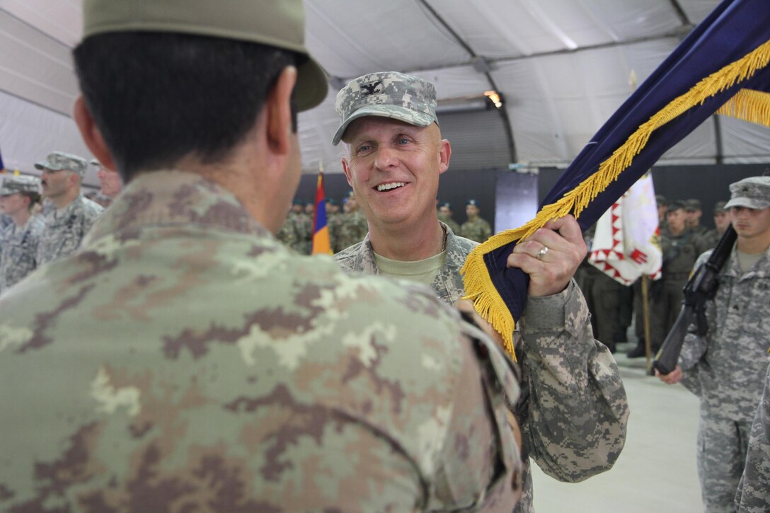 U.S. Army Col. Vernon Simpson, commander of the 30th Armored Brigade Combat Team, accepts the NATO colors from Italian Maj. Gen. Francesco Paolo Figliuolo, the Kosovo Force commanding general, during a Multinational Battle Group-East transfer of authority ceremony July 9, 2015, at Camp Bondsteel, Kosovo. The 30th ABCT, an Army National Guard unit from North Carolina, will lead a multinational force supporting NATO’s peace mission in Kosovo for approximately nine months. (U.S. Army photo by Sgt. Erick Yates, Multinational Battle Group-East)