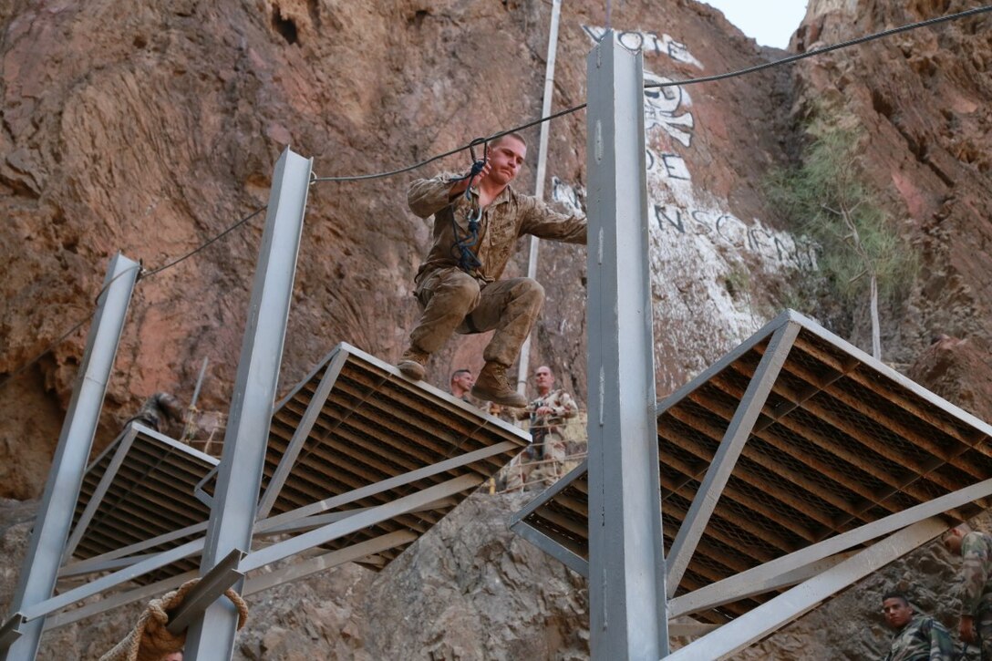 ARTA BEACH, Djibouti (Sept. 27, 2015) A U.S. Marine with the 15th Marine Expeditionary Unit jumps between platforms during a desert survival obstacle course alongside the members of the French 5th Overseas Combined Arms Regiment (RIAOM). Elements of the 15th MEU are training with the 5th RIAOM in Djibouti in order to improve interoperability between the MEU and the French military. (U.S. Marine Corps photo by Sgt. Steve H. Lopez/Released)